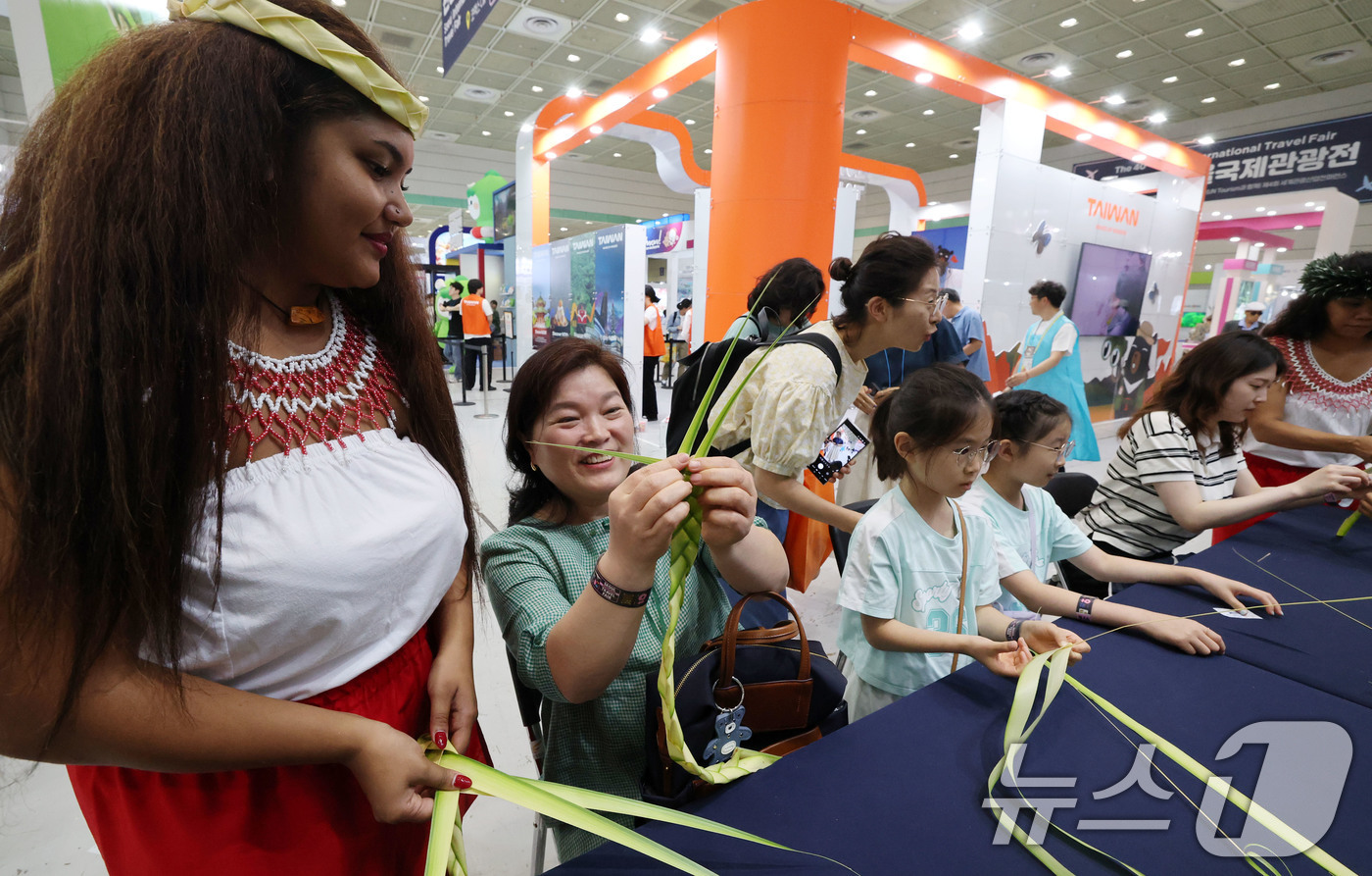 (서울=뉴스1) 박세연 기자 = 5일 서울 강남구 코엑스에서 열린 제40회 서울국제관광전을 찾은 관람객들이 마리아나 부스에서 전통공예를 배우고 있다.40주년을 맞이한 여행 축제인 …