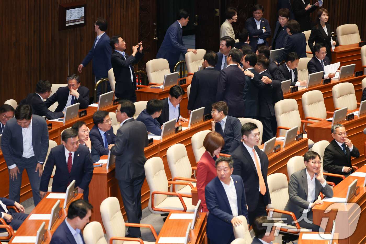 (서울=뉴스1) 안은나 기자 = 더불어민주당 의원들이 5일 오후 서울 여의도 국회 본회의장에서 기념 촬영하는 가운데 국민의힘 의원들이 입장하고 있다. 2025.6.5/뉴스1