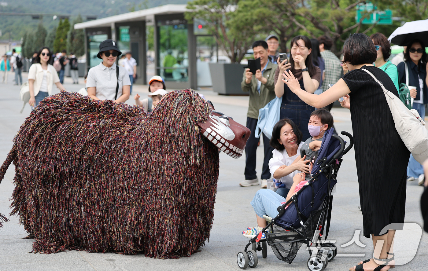 (서울=뉴스1) 오대일 기자 = 제1회 국악의날인 5일 오후 서울 종로구 광화문광장에서 열린 '여민락 대축제' 국악의 날 기념 퍼레이드에서 북청사자놀음을 지켜보던 어린이가 울음보를 …