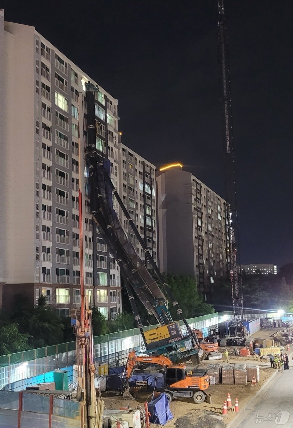 본문 이미지 - 5일 오후 10시 13분께 경기 용인시 기흥구 서천동 인덕원~동탄 복선전철 공사 현장에서 대형 중장비인 천공기(지반을 뚫는 건설기계)가 15층 높이 아파트를 덮쳤다. (독자 제공. 재판매 및 DB 금지) 2025.6.5/뉴스1 ⓒ News1 김기현 기자