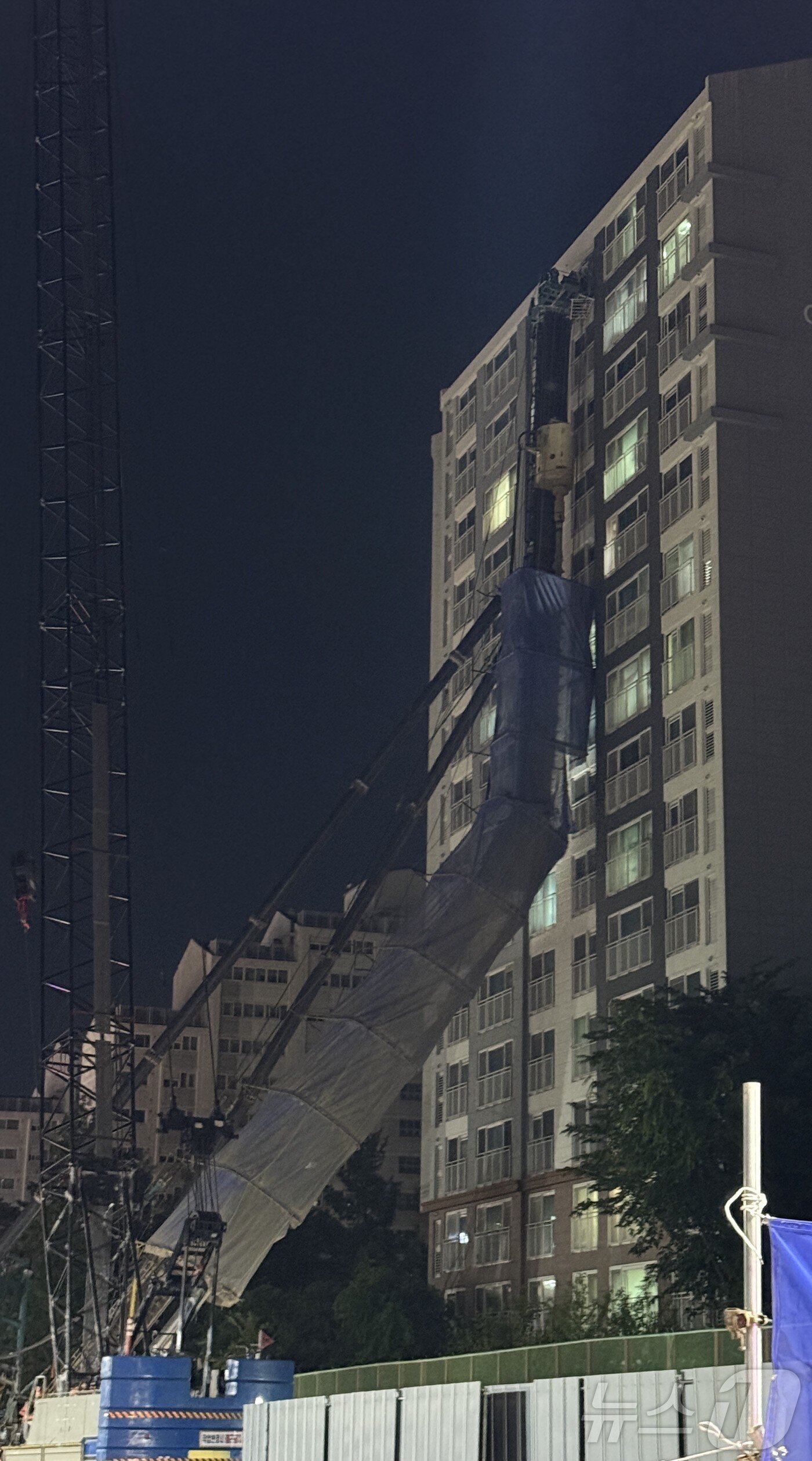 본문 이미지 - 5일 오후 10시 13분께 경기 용인시 기흥구 서천동 인덕원~동탄 복선전철 공사 현장에서 대형 중장비인 천공기(지반을 뚫는 건설기계)가 15층 높이 아파트를 덮쳤다.  (독자 제공. 재판매 및 DB 금지) 2025.6.5/뉴스1 ⓒ News1 김기현 기자