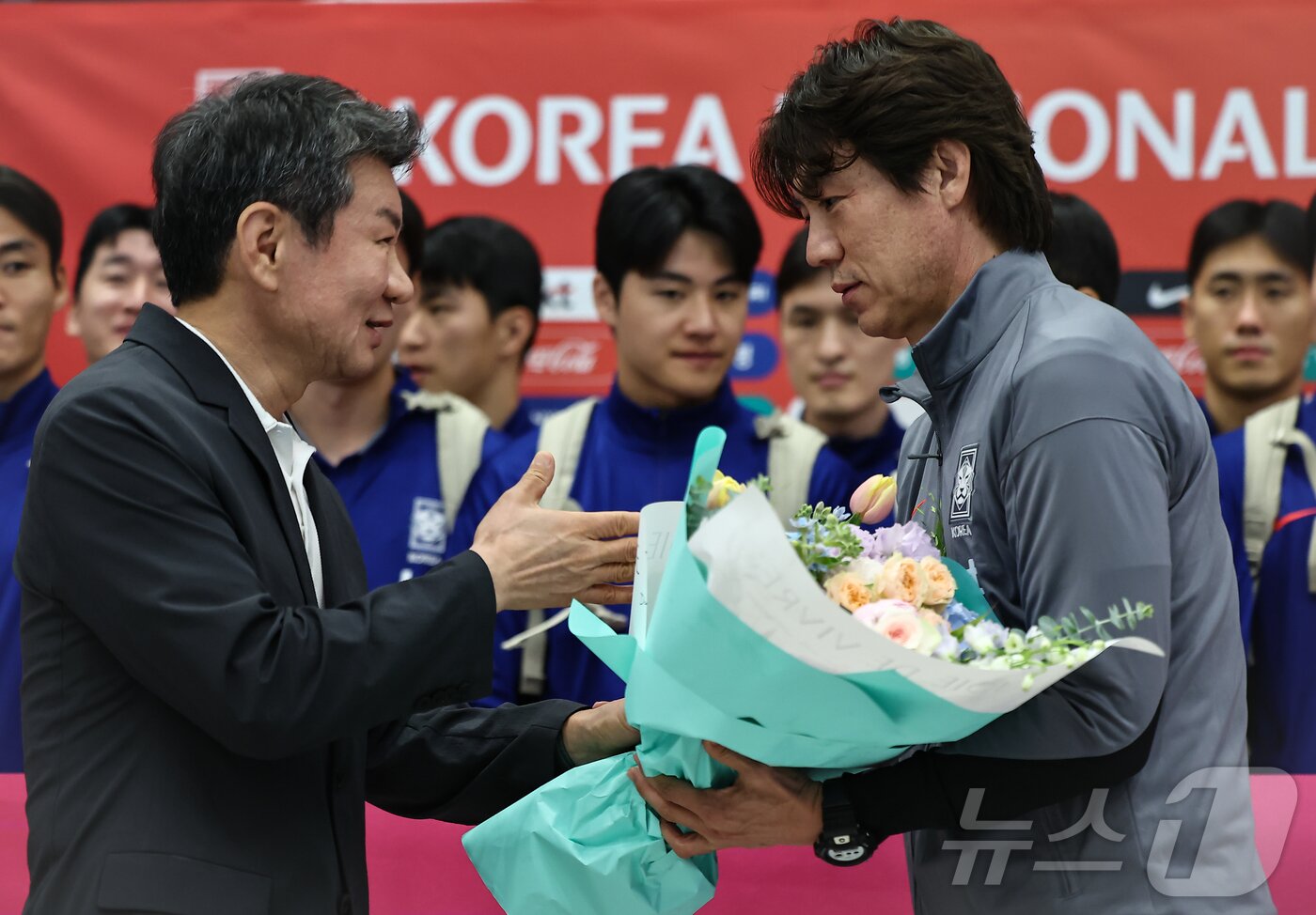 본문 이미지 - 홍명보 감독이 6일 이라크와 북중미 월드컵 예선경기를 마치고 인천국제공항 제1터미널을 통해 귀국하며 정몽규 대한축구협회장에게 꽃을 받고 있다. 대표팀은 이라크와 원정경기에서 2대0으로 승리하며 11회 연속 월드컵 본선 진출을 확정했다. 2025.6.6/뉴스1 ⓒ News1 김도우 기자