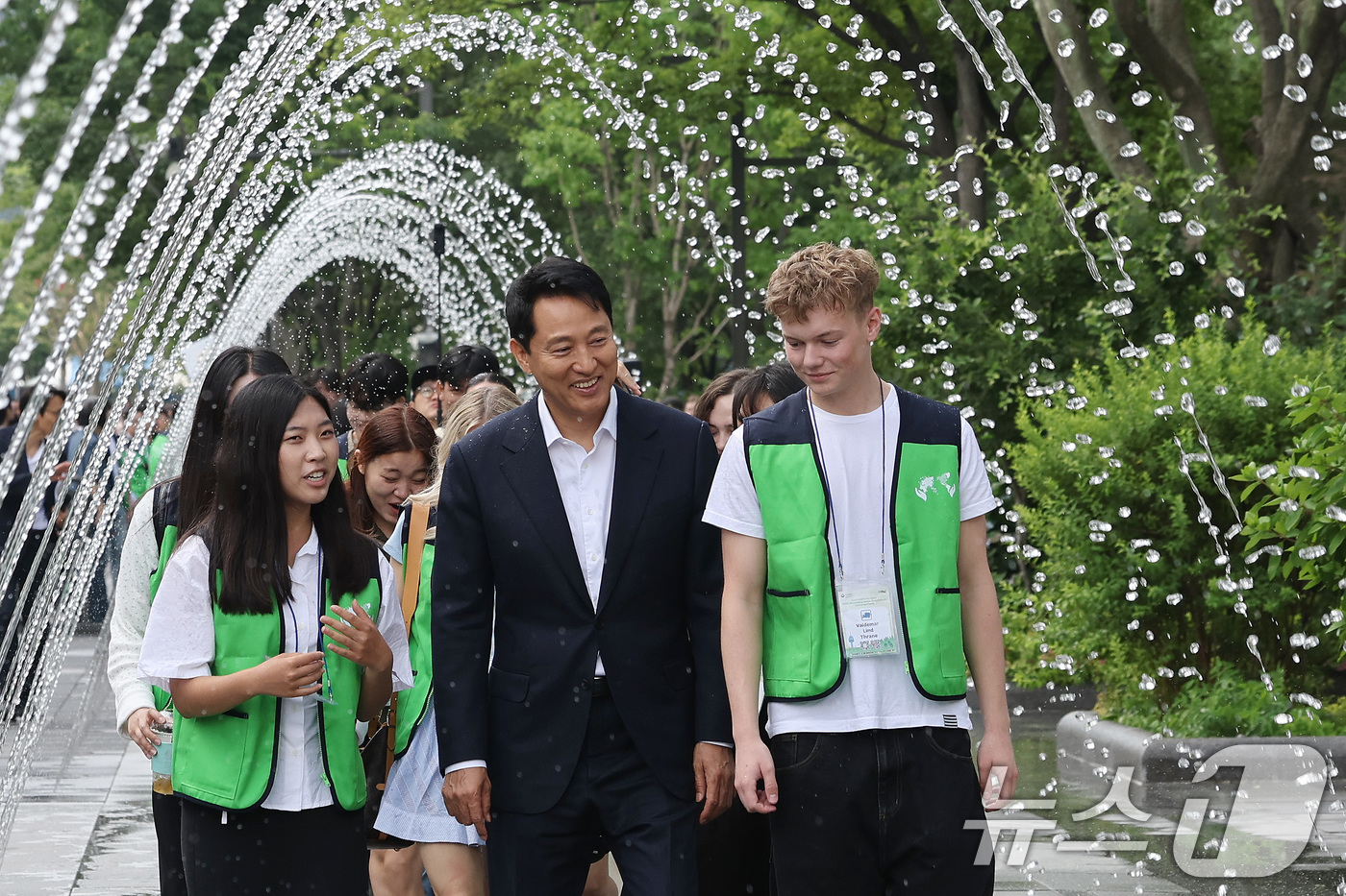 (서울=뉴스1) 이동해 기자 = 오세훈 서울시장이 8일 서울 종로구 광화문광장에서 유엔참전국 후손 교류캠프 참가자들과 터널분수를 걷고 있다.감사의 정원은 6·25전쟁 당시 대한민국 …