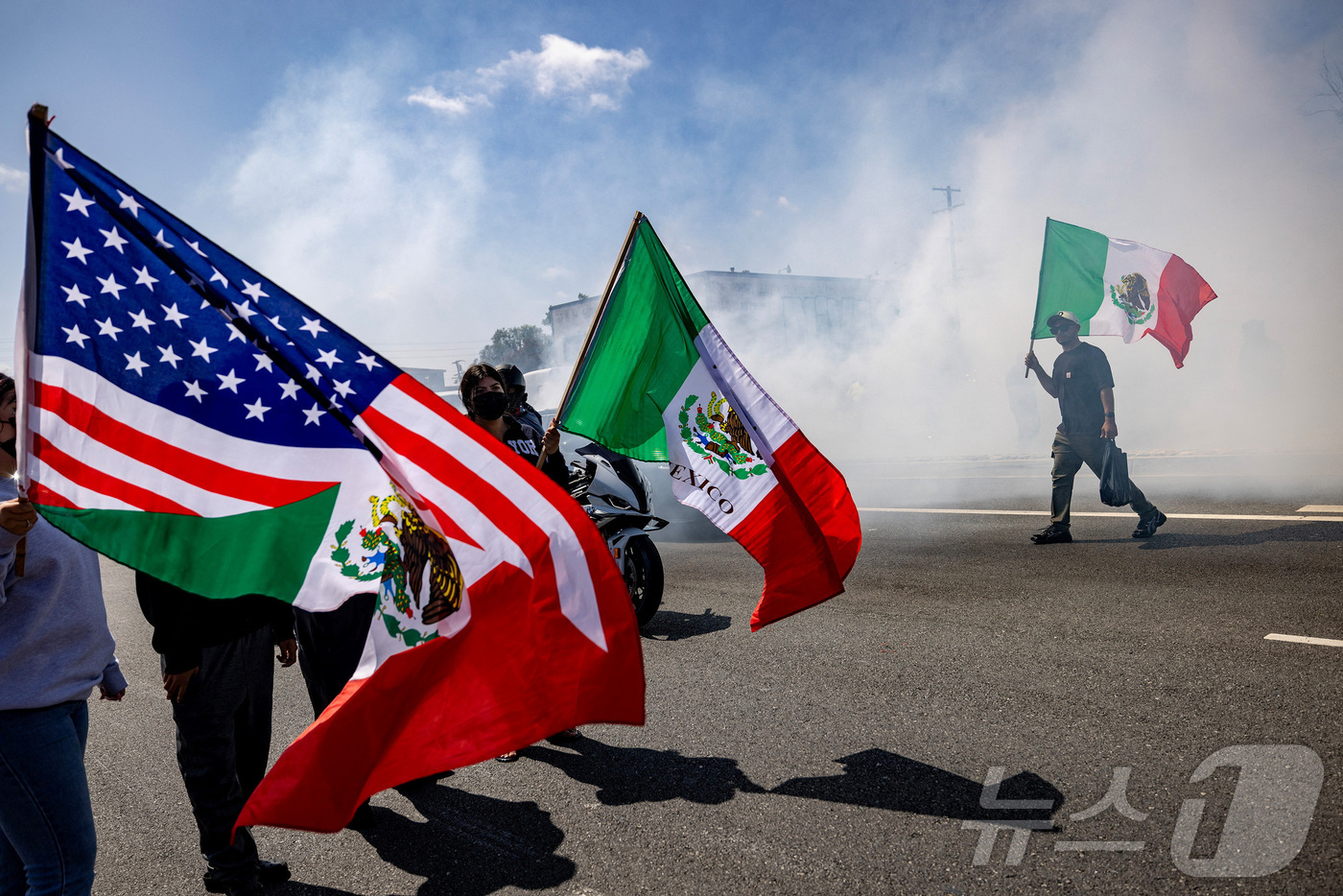 (파라마운트 로이터=뉴스1) 이창규 기자 = 이민세관단속국(ICE)이 미국 캘리포니아주 로스앤젤레스 카운티의 파라마운트에서 불법 체류자들을 체포한 후 경찰과 시위대 간 대치 중 한 …