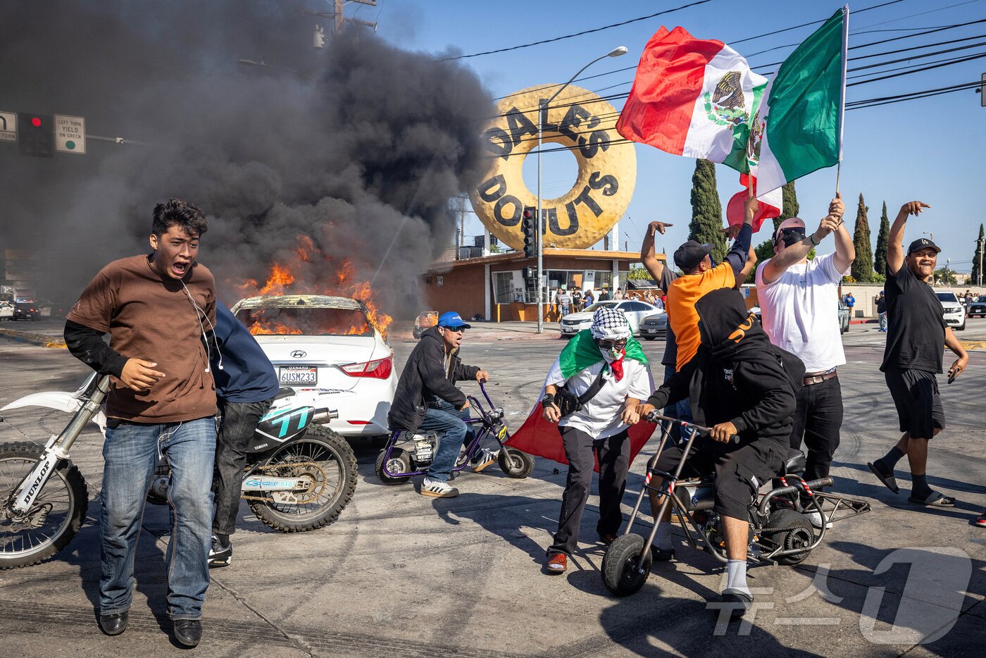 본문 이미지 - 미국 이민세관단속국&#40;ICE&#41;이 7일&#40;현지시간&#41; 캘리포니아주 로스앤젤레스 카운티의 파라마운트에서 불법 체류자 단속에 나선 후 시위가 격화되고 있는 가운데 시위대들이 교차로에 모여 있다. 2025.6.7./뉴스1 ⓒ 로이터=뉴스1 ⓒ News1 이창규 기자