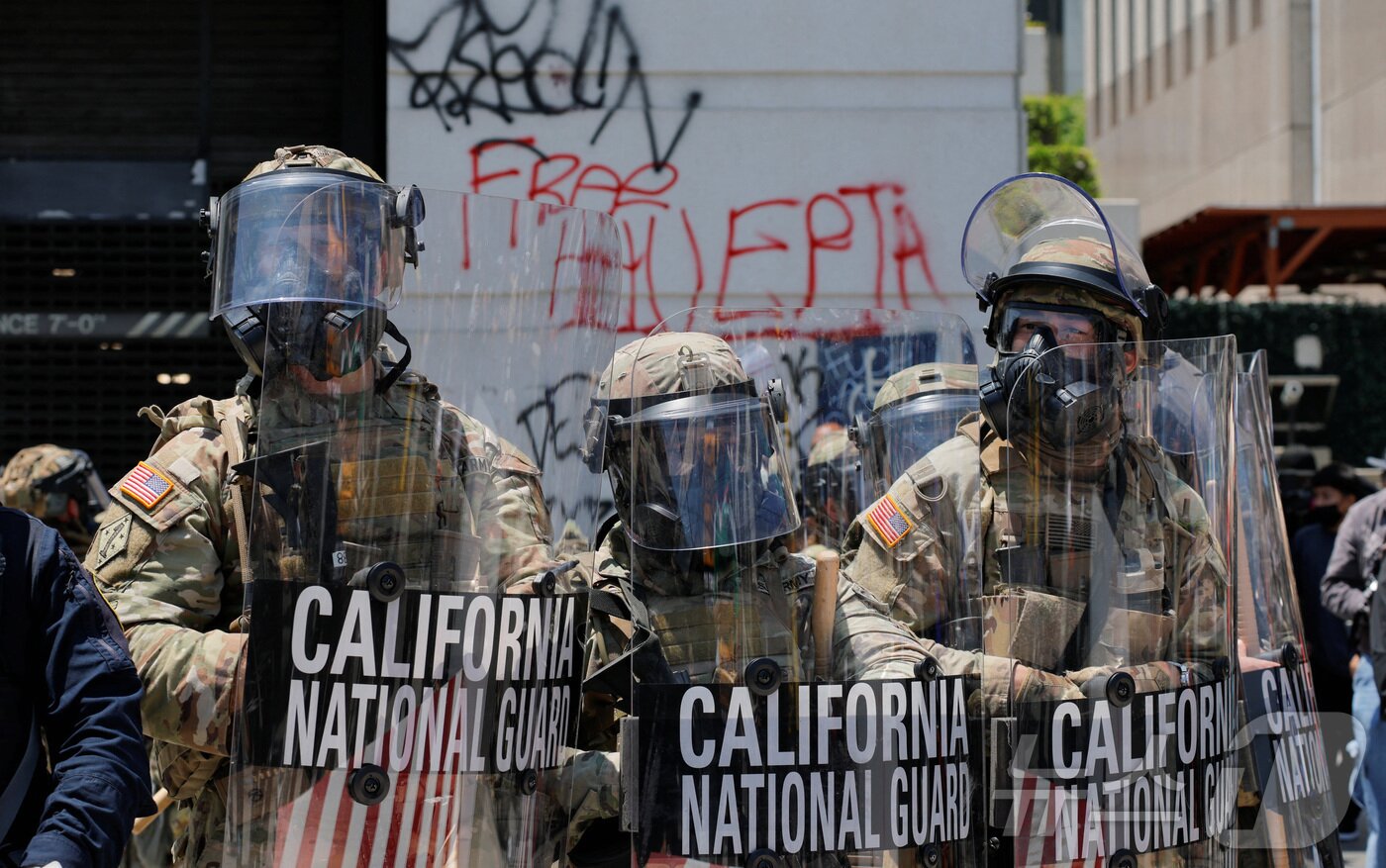 본문 이미지 - 미국 캘리포니아주 로스앤젤레스&#40;LA&#41;에서 발생한 불법 이민자 단속 및 추방 작전에 반대하는 시위에 대응하기 위해 도널드 트럼프 미국 대통령이 배치를 명령한 캘리포니아 주방위군이 8일&#40;현지시간&#41; 시위대와 대치하고 있다. 2025.06.08 ⓒ 로이터=뉴스1 ⓒ News1 류정민 특파원