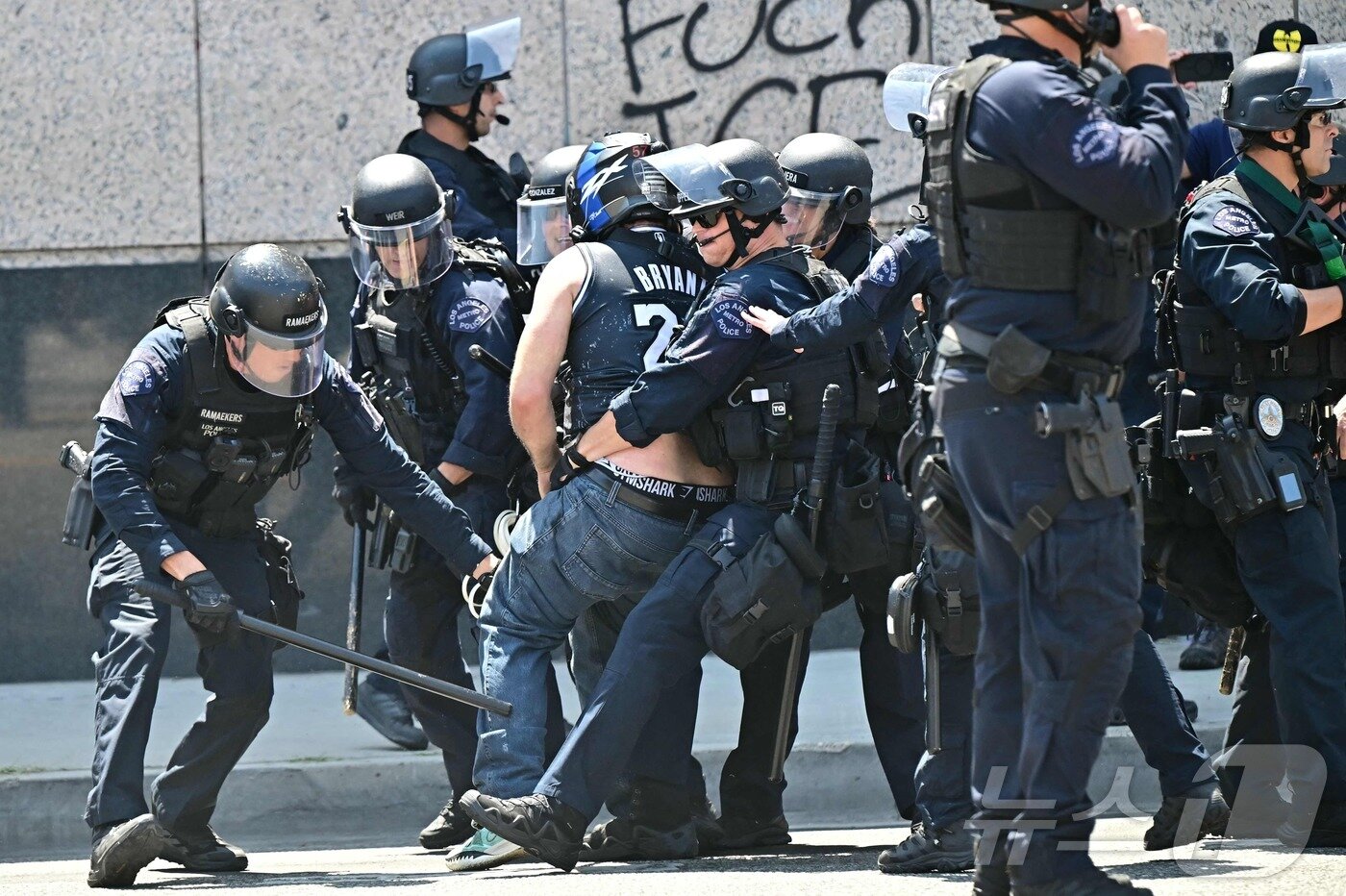 본문 이미지 - 8일&#40;현지시간&#41; 미국 캘리포니아주 로스앤젤레스 시내 메트로폴리탄 구치소 MDC 밖에서 경찰 및 관계자들이 시위대와 충돌하고 있다. ⓒ AFP=뉴스1 ⓒ News1 김성진 기자