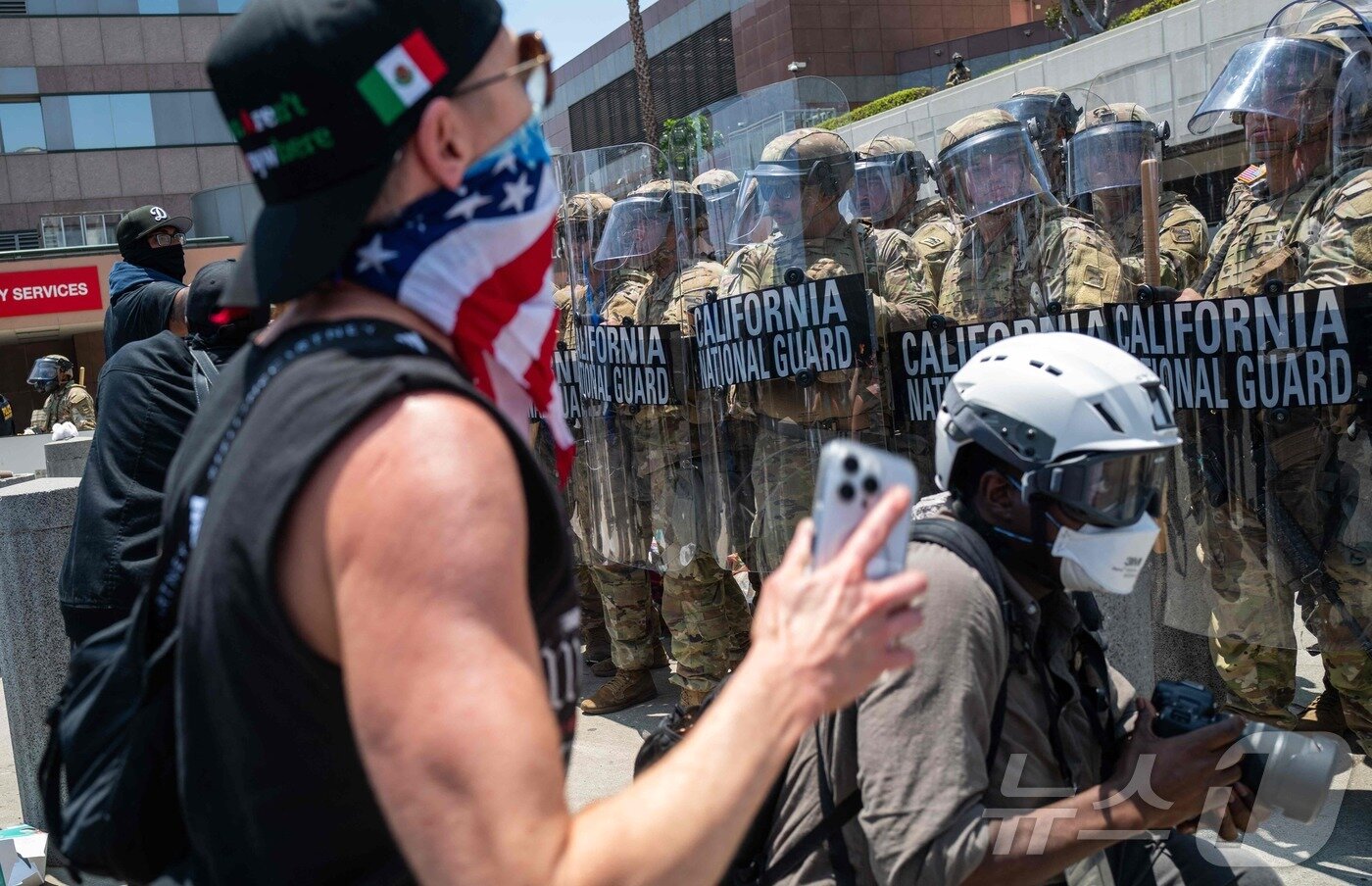 본문 이미지 - 8일(현지시간) 도널드 트럼프 대통령의 명령에 따라 배치된 캘리포니아주 주방위군이 로스앤젤레스(LA) 시내에 소재한 구치소 앞에서 시위대와 대치하고 있다. 2025.06.08 ⓒ AFP=뉴스1 ⓒ News1 류정민 특파원