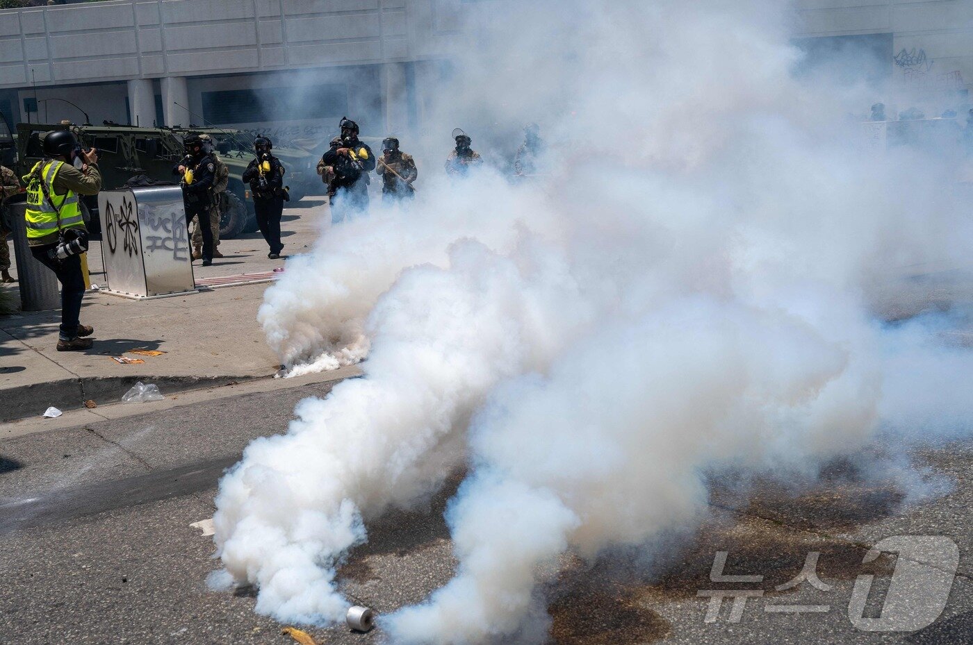 본문 이미지 - 8일(현지시간) 캘리포나이 주방위군과 로스앤젤레스(LA) 경찰 당국 등이 불법이민자에 단속에 반발해 거리에 나선 시위대를 해산하기 위해 발사한 최루탄 연기가 현장에 퍼지고 있다. 2025.06.08 ⓒ AFP=뉴스1 ⓒ News1 류정민 특파원