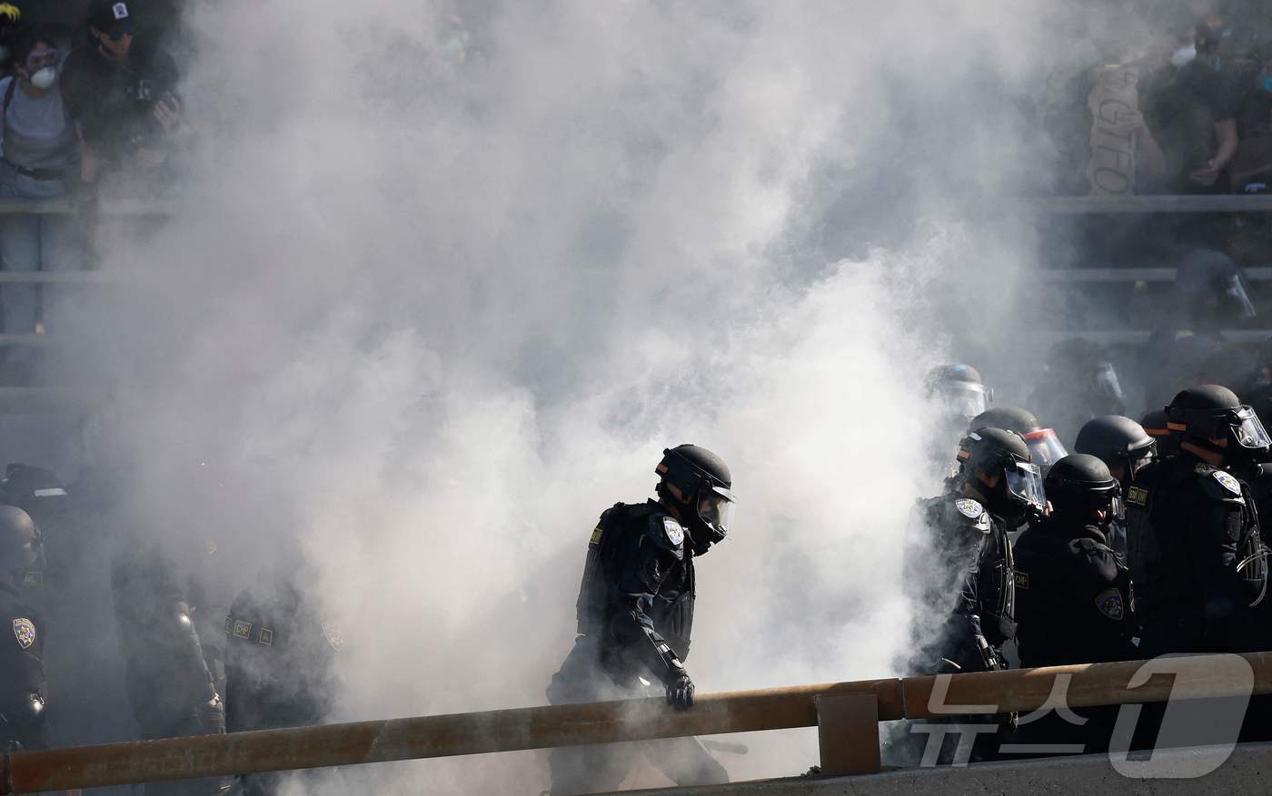 본문 이미지 - 8일(현지시간) 미국 LA에서 경찰이 고속도로를 막으며 시위대를 해산하고 있다. ⓒ AFP=뉴스1