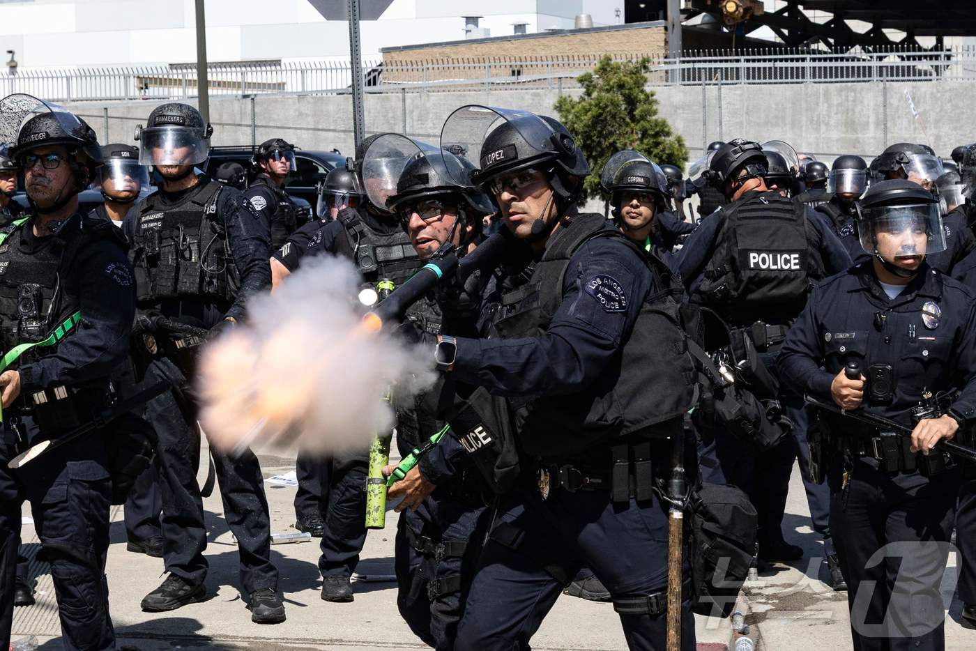 본문 이미지 - 8일(현지시간) 미국 LA 연방청사 인근에서 경찰이 시위대를 향해 비살상 무기를 발사하고 있다.ⓒ AFP=뉴스1