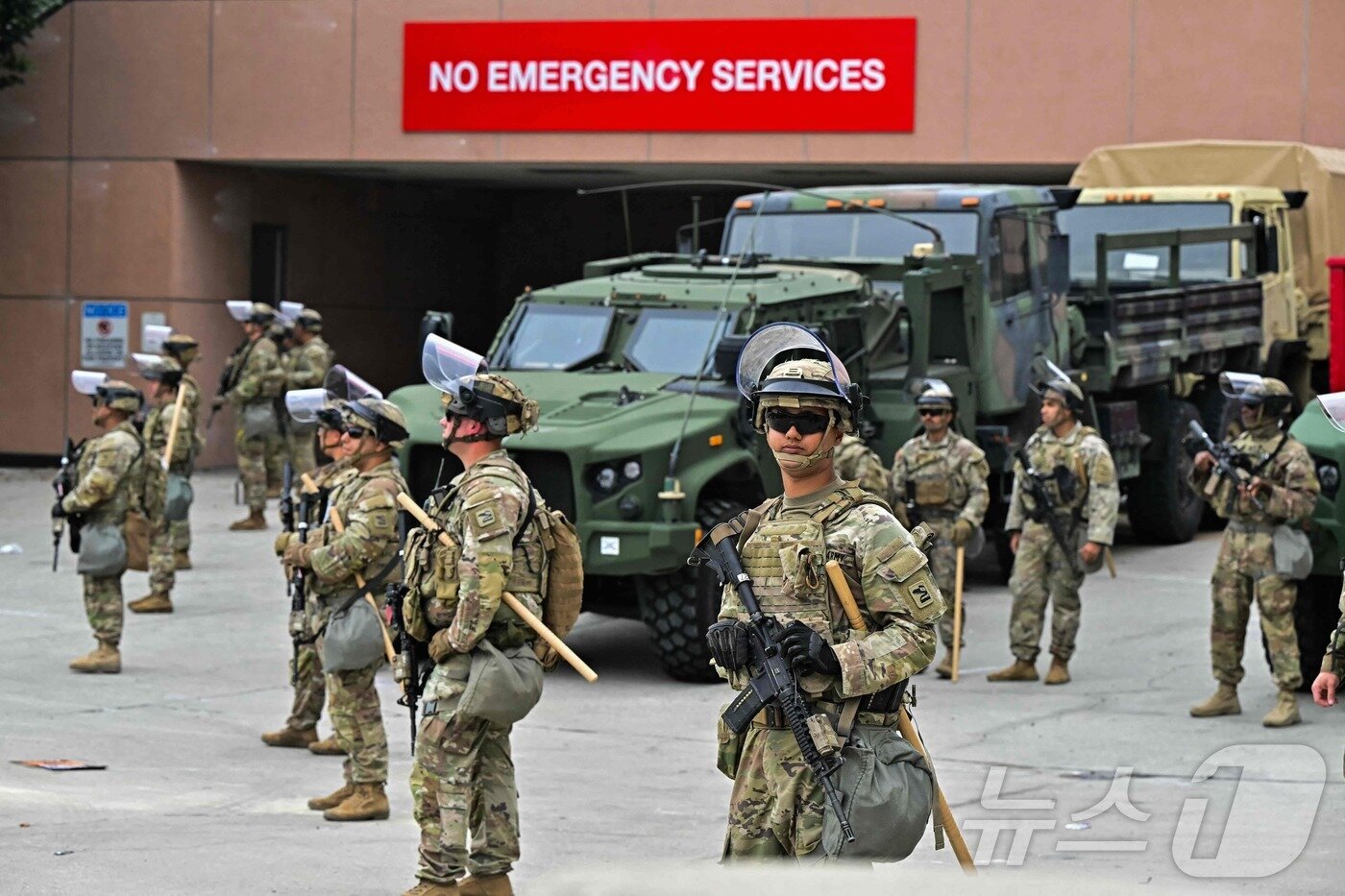 본문 이미지 - 8일(현지시간) 미국 LA 메트로폴리탄 구치소 인근에서 주 방위군들이 경계를 서고 있다. ⓒ AFP=뉴스1