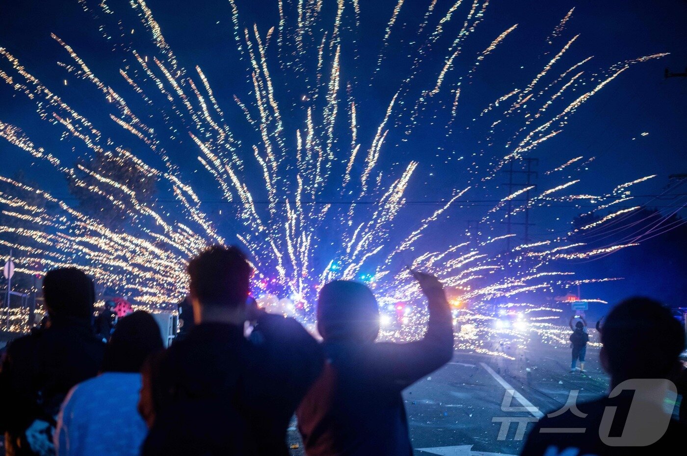 본문 이미지 - 7일(현지시간) 미국 LA에서 열린 연방 이민법 집행에 대한 항의 시위에서 불꽃이 터지고 있다.ⓒ AFP=뉴스1