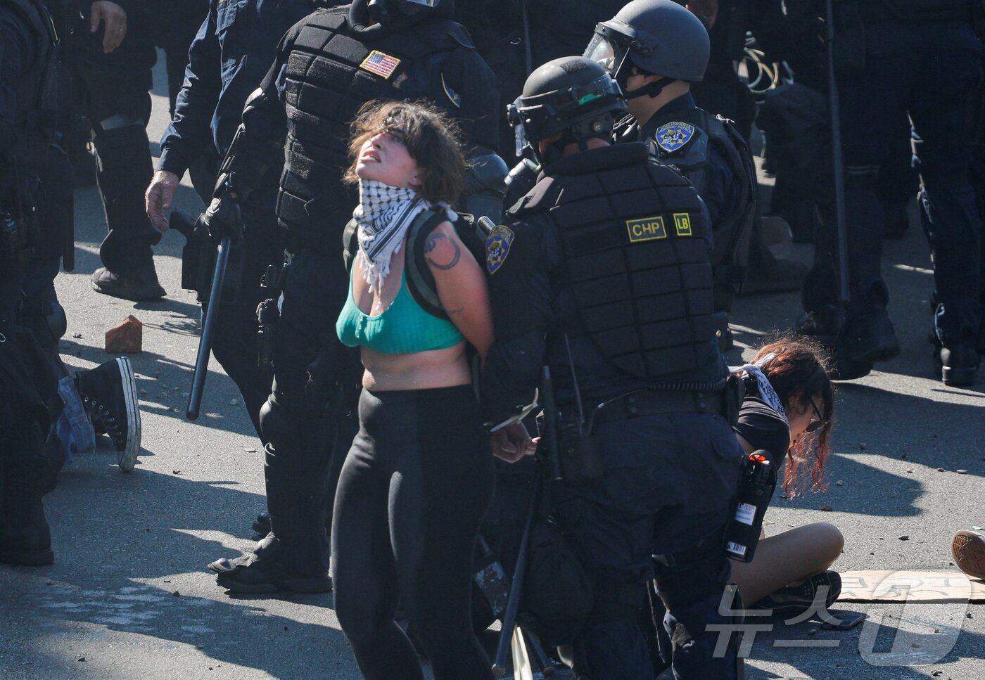 본문 이미지 - 8일(현지시간) 미국 LA에서 열린 연방 이민법 집행에 대한 항의 시위에서 한 시위자가 경찰에 체포되고 있다.  ⓒ 로이터=뉴스1