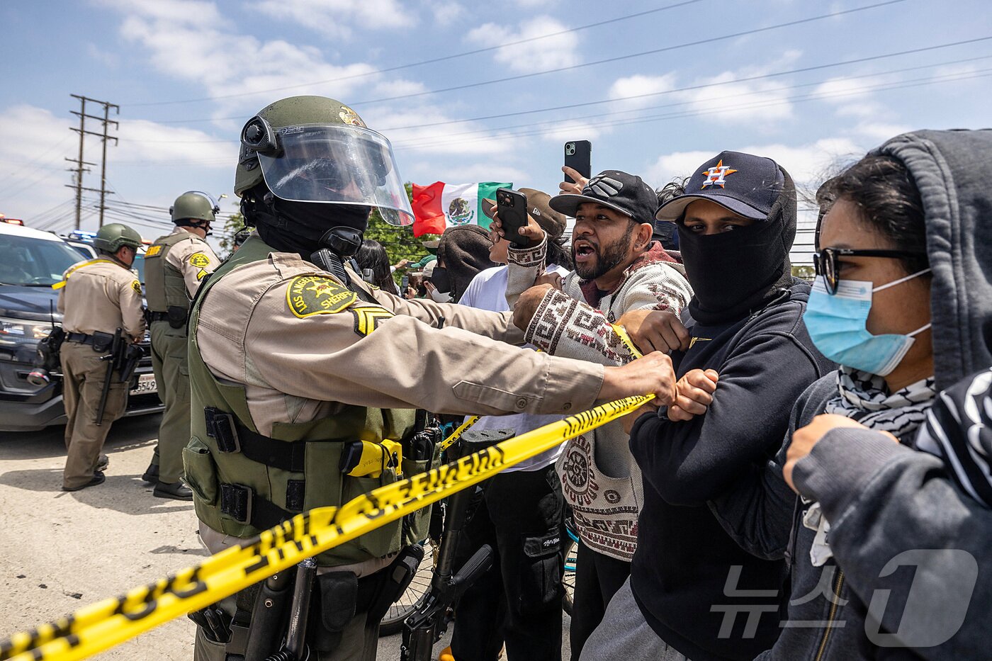 본문 이미지 - 7일(현지시간) 미국 LA에서 열린 연방 이민법 집행에 대한 항의 시위에서 보안관이 시위대를 제압하고 있다.ⓒ 로이터=뉴스1