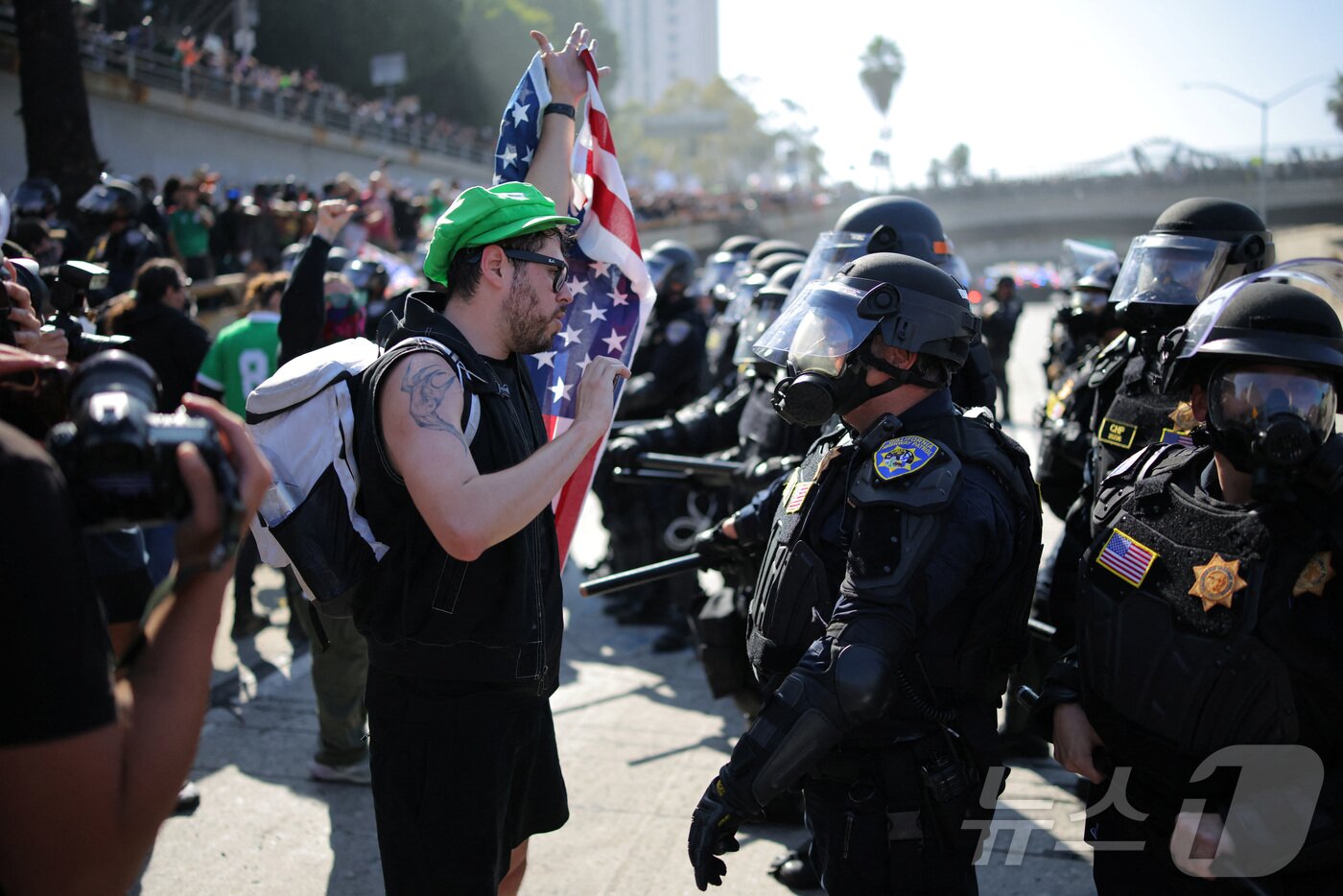 본문 이미지 - 8일(현지시간) 미국 LA에서 열린 연방 이민법 집행에 대한 항의 시위에서 경찰과 시위대가 대치하고 있다. ⓒ 로이터=뉴스1