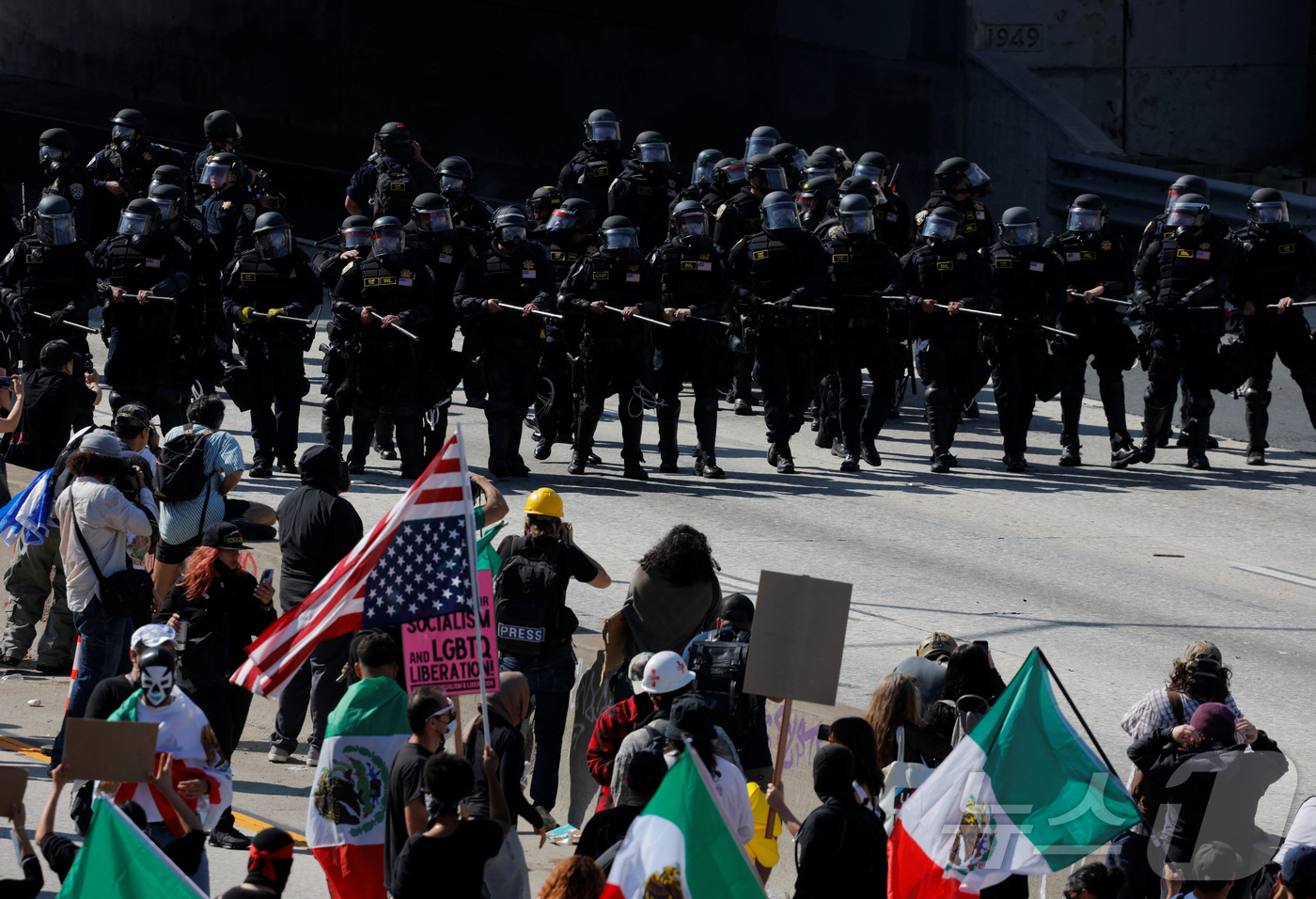 (로스앤젤레스 로이터=뉴스1) 김지완 기자 = 8일(현지시간) 미국 캘리포니아주 로스앤젤레스(LA)에서 도널드 트럼프 행정부의 불법이민 단속에 항의하는 시위대가 경찰 병력과 대치하 …