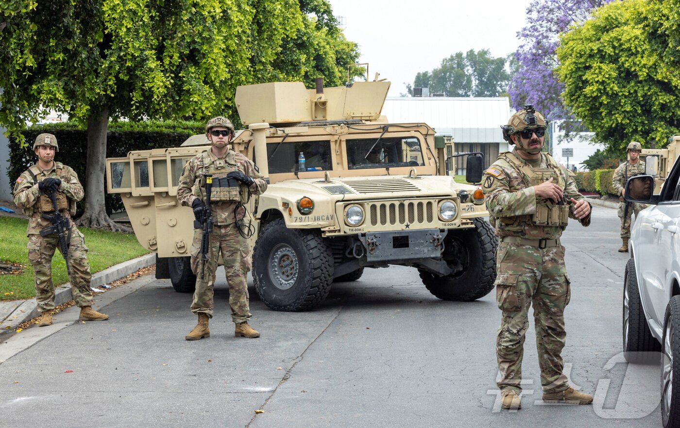 본문 이미지 - 지난 6월 미국 캘리포니아 주방위군이 로스앤젤레스&#40;LA&#41;의 패러마운트 비즈니스 센터 주차장에서 경계근무를 서고 있다. LA에서는 도널드 트럼프 행정부의 불법이민 단속에 항의하는 시위가 사흘째 이어지고 있는 가운데, 트럼프 대통령은 시위 진압을 위해 7일 이례적으로 주방위군 2000명 투입을 명령하면서 시위 양상이 더욱 격화되고 있다. 2025.06.08 ⓒ 로이터=뉴스1 ⓒ News1 김지완 기자