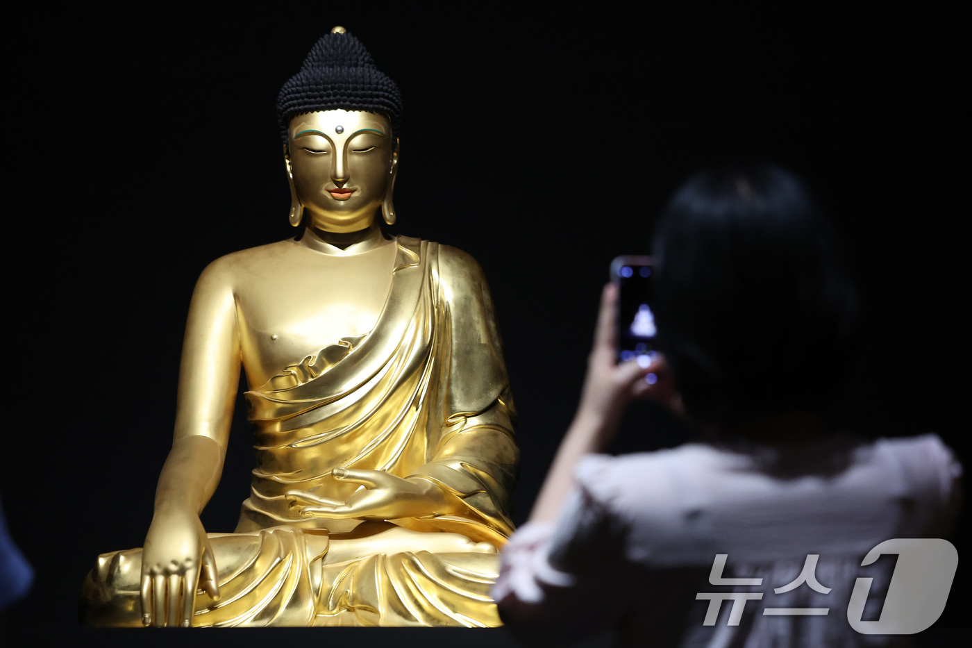 (서울=뉴스1) 이동해 기자 = 7일 서울 용산구 국립중앙박물관에서 열린 '새 나라 새 미술:조선 전기 미술 대전' 특별전에서 관람객이 조계사 목조여래좌상을 살펴보고 있다.국립중앙 …