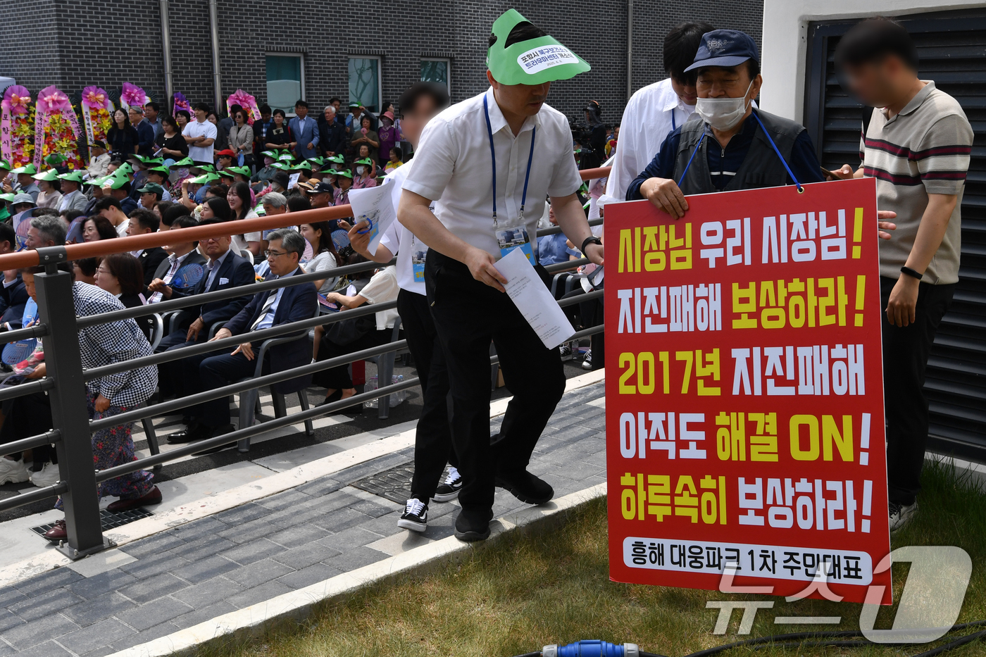 (포항=뉴스1) 최창호 기자 = 9일 경북 포항시 북구 흥해읍에서 열린 북구보건소와 트라우마 개소식에서 '포항 촉발지진' 피해자가 보상 촉구 1인 시위를 하고 있다. 2025.6. …