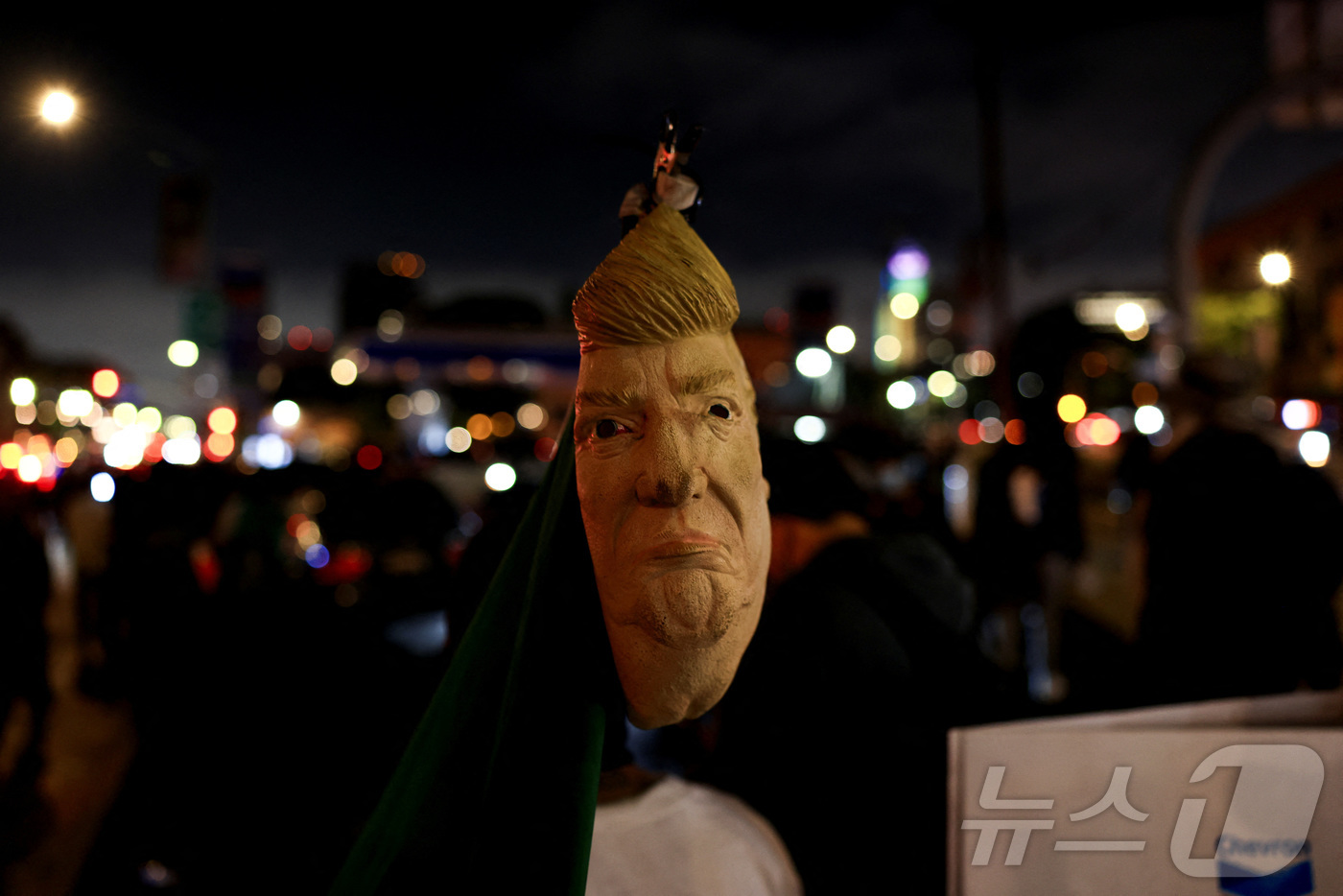 (LA 로이터=뉴스1) 신기림 기자 = 8일(현지시간) 미국 캘리포니아주 로스앤젤레스(LA) 시내에서 열린 연방 이민단속 반대 시위에서 한 시위자가 도널드 트럼프 미국 대통령을 묘 …