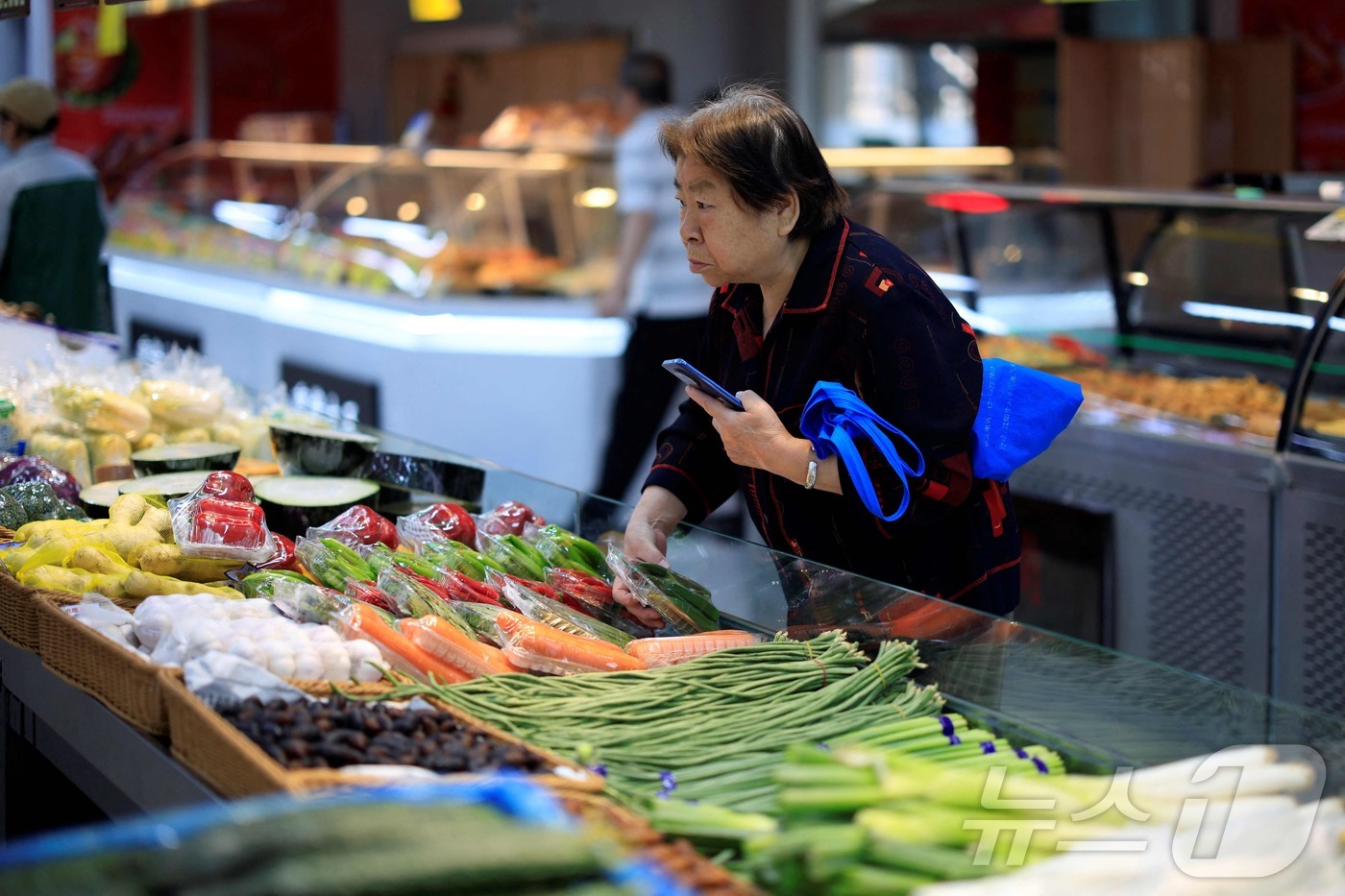 (선양 AFP=뉴스1) 권영미 기자 = 2025년 6월9일 중국 선양의 한 슈퍼에서 한 여성이 식료품을 고르고 있다. 2025.06.09.ⓒ AFP=뉴스1