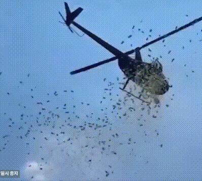 본문 이미지 - 한 남성이 27일(현지시간) 미국 미시간주 디트로이트에서 자신의 아버지를 기리기 위해 헬리콥터로 상공에 돈을 뿌리고 있다.(사진 @SDNInsider 캡쳐)