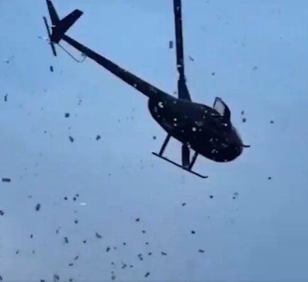 본문 이미지 - 한 남성이 27일(현지시간) 미국 미시간주 디트로이트에서 자신의 아버지를 기리기 위해 헬리콥터로 상공에 돈을 뿌리고 있다.(사진 @SDNInsider 캡쳐)