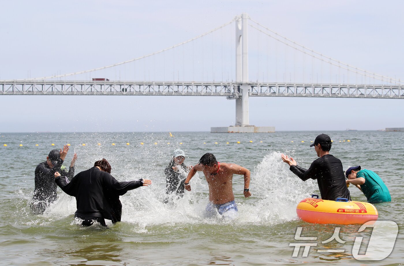 본문 이미지 - 무더위가 기승을 부린 1일 개장한 부산 수영구 광안리해수욕장을 찾은 관광객들이 물놀이를 즐기며 더위를 식히고 있다. 부산 7개 해수욕장 중 해운대·송정해수욕장은 지난달 21일 개장했으며, 광안리·송도·다대포·일광·임랑해수욕장 등 5개 해수욕장은 이날 문을 열었다. 2025.7.1/뉴스1 ⓒ News1 윤일지 기자