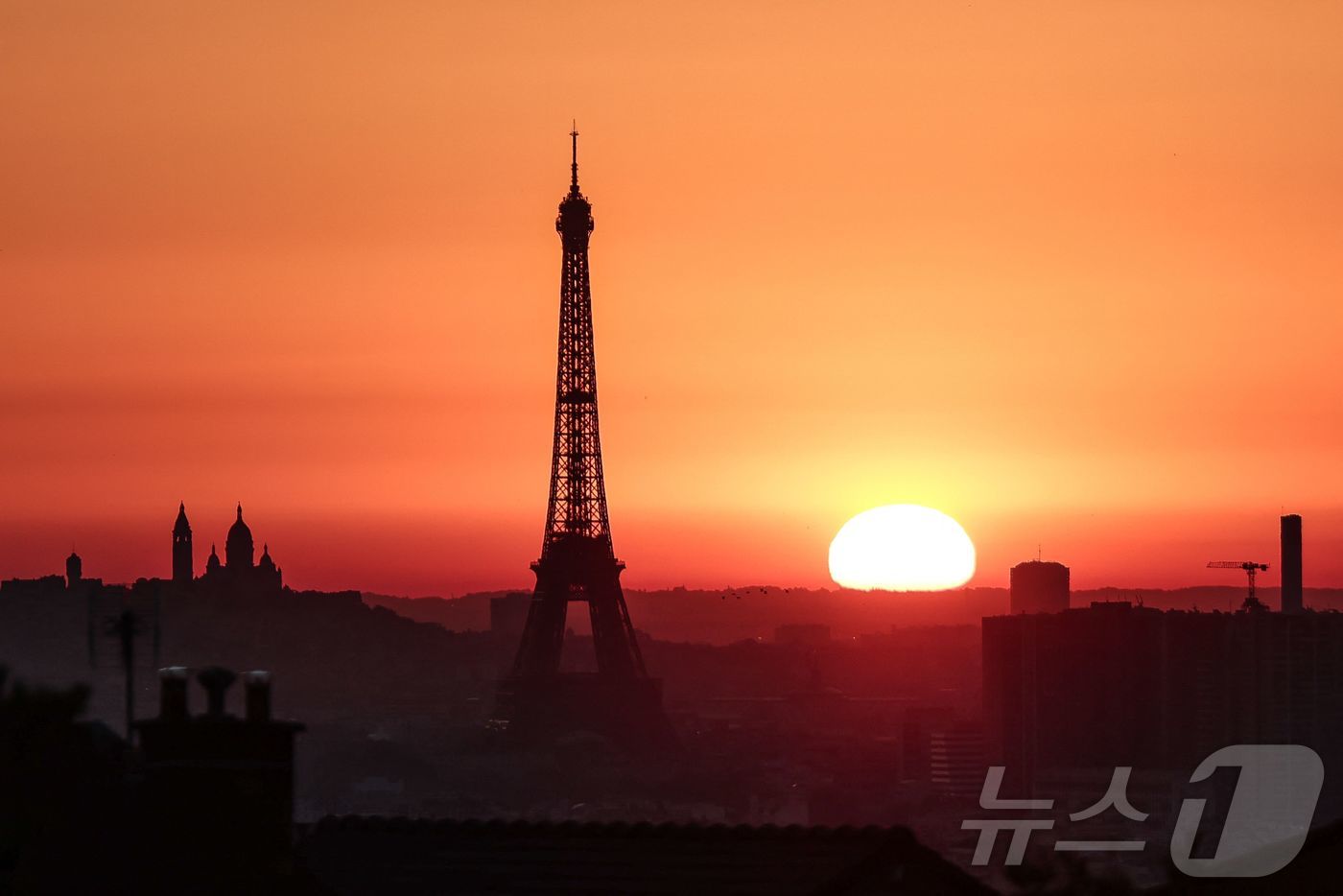 (파리 AFP=뉴스1) 신기림 기자 = 1일(현지시간) 프랑스 파리의 에펠탑과 몽마르뜨 언덕 꼭대기에 있는 사크레 쾨르 대성당 옆에서 해가 떠오르고 있다. 유럽을 강타한 폭염으로 …