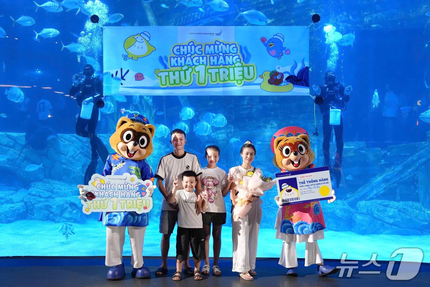 본문 이미지 - 누적 관람객 100만 명 달성을 기념해 기념 촬영 중인 가족 손님들의 모습(롯데월드 제공)