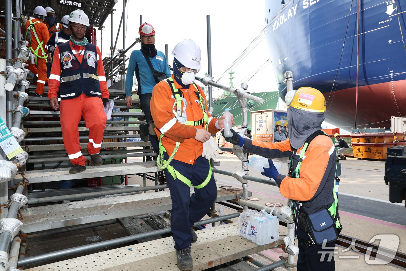 본문 이미지 - 휴식을 위해 하선 하는 작업자들에게 전달되고 있는 얼음 생수.(한화오션. 재판매 및 DB금지)