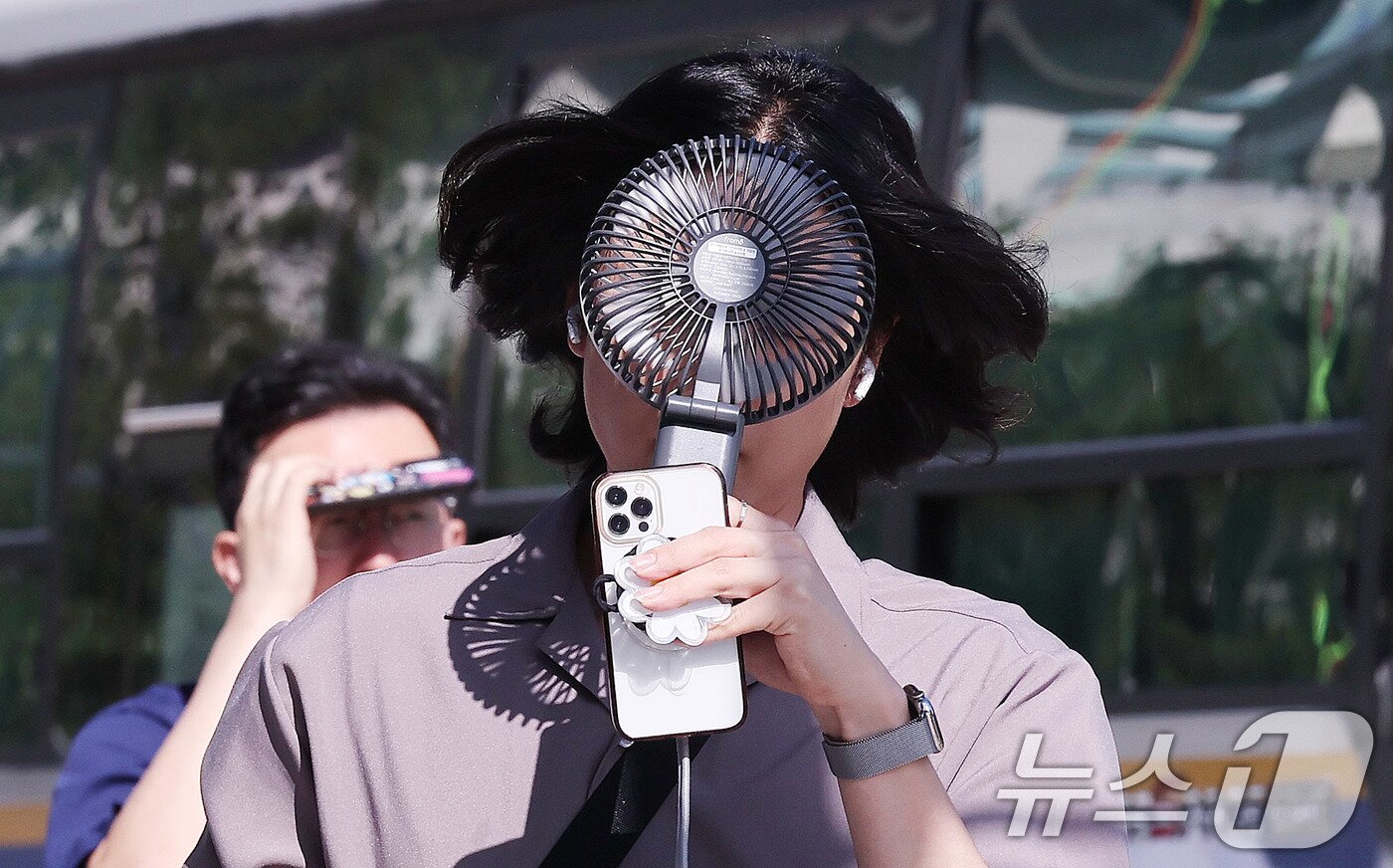 본문 이미지 - 폭염이 연일 이어지는 10일 서울 종로구 광화문광장 인근에서 한 시민이 손선풍기를 얼굴에 대며 출근하고 있다. 2025.7.10/뉴스1 ⓒ News1 박지혜 기자