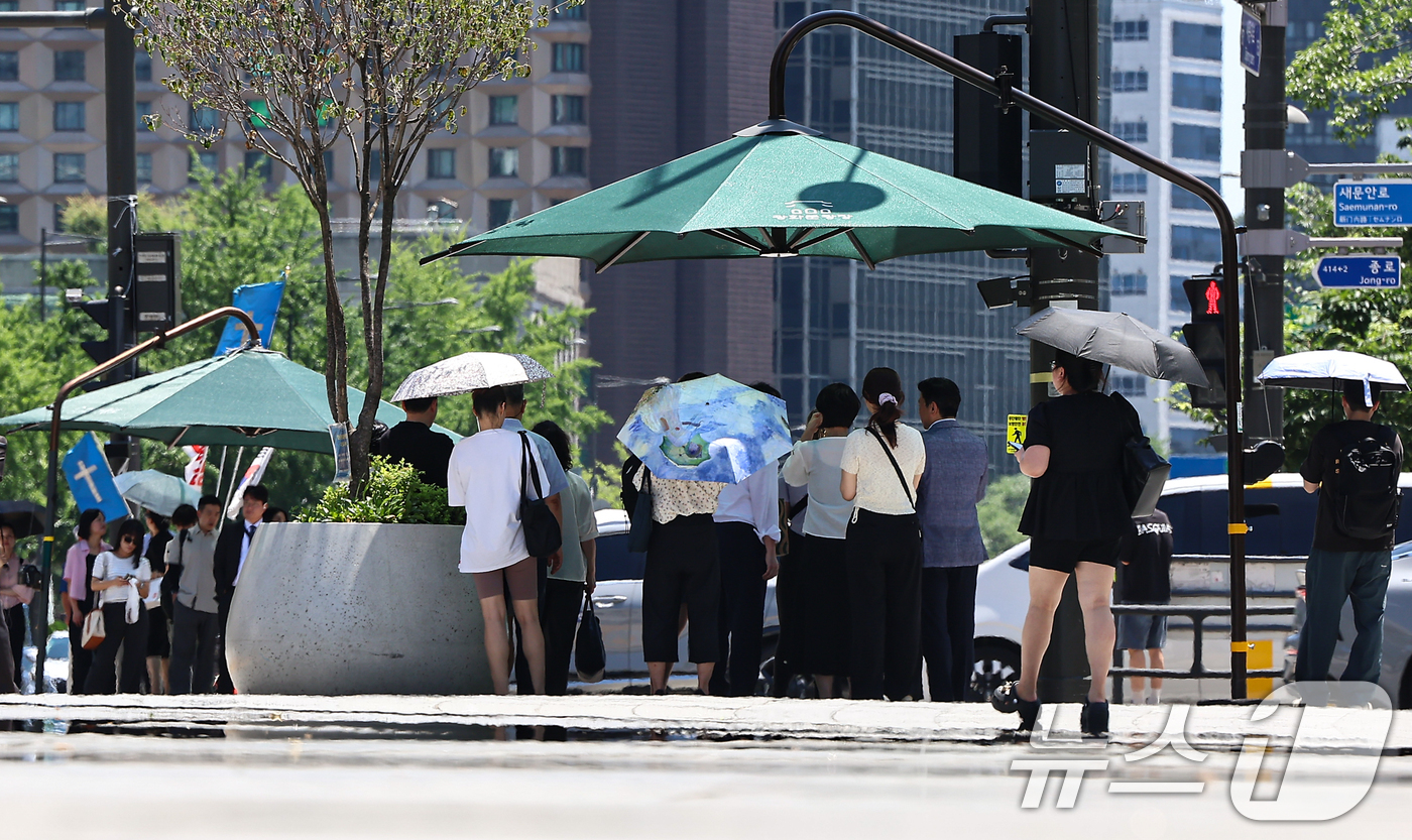 (서울=뉴스1) 김도우 기자 = 폭염이 이어진 10일 서울 종로구 광화문네거리에서 시민들이 그늘막 아래에서 횡단보도 신호를 기다리고 있다. 2025.7.10/뉴스1