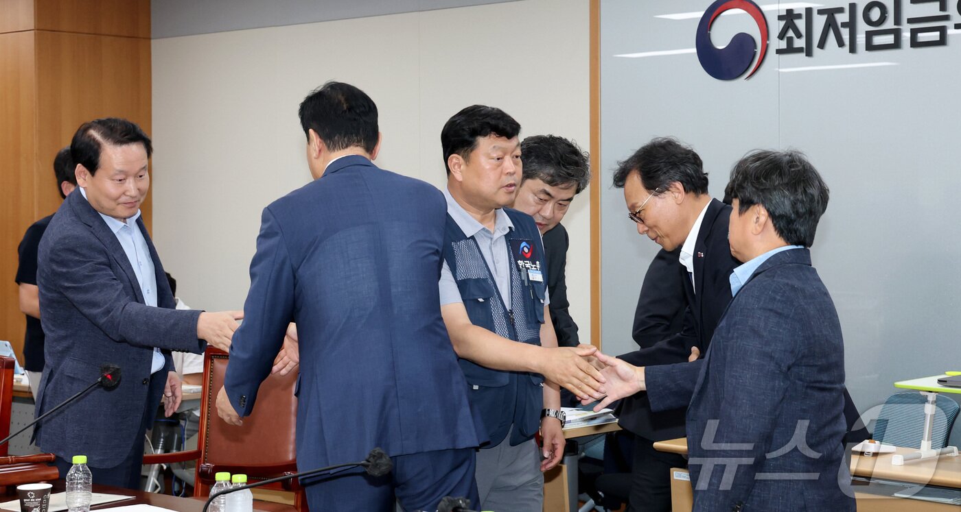 본문 이미지 - 10일 저녁 세종시 정부세종청사 고용노동부에서 열린 최저임금위원회 제12차 전원회의에서 사용자위원과 한국노총 근로자위원들만이 참여하여 2026년 최저임금을 10,320원으로 합의하며 류기정 사용자위원과 류기섭 근로자위원 등이 회의장을 떠나며 인사를 나누고 있다. 2025.7.10/뉴스1 ⓒ News1 김기남 기자