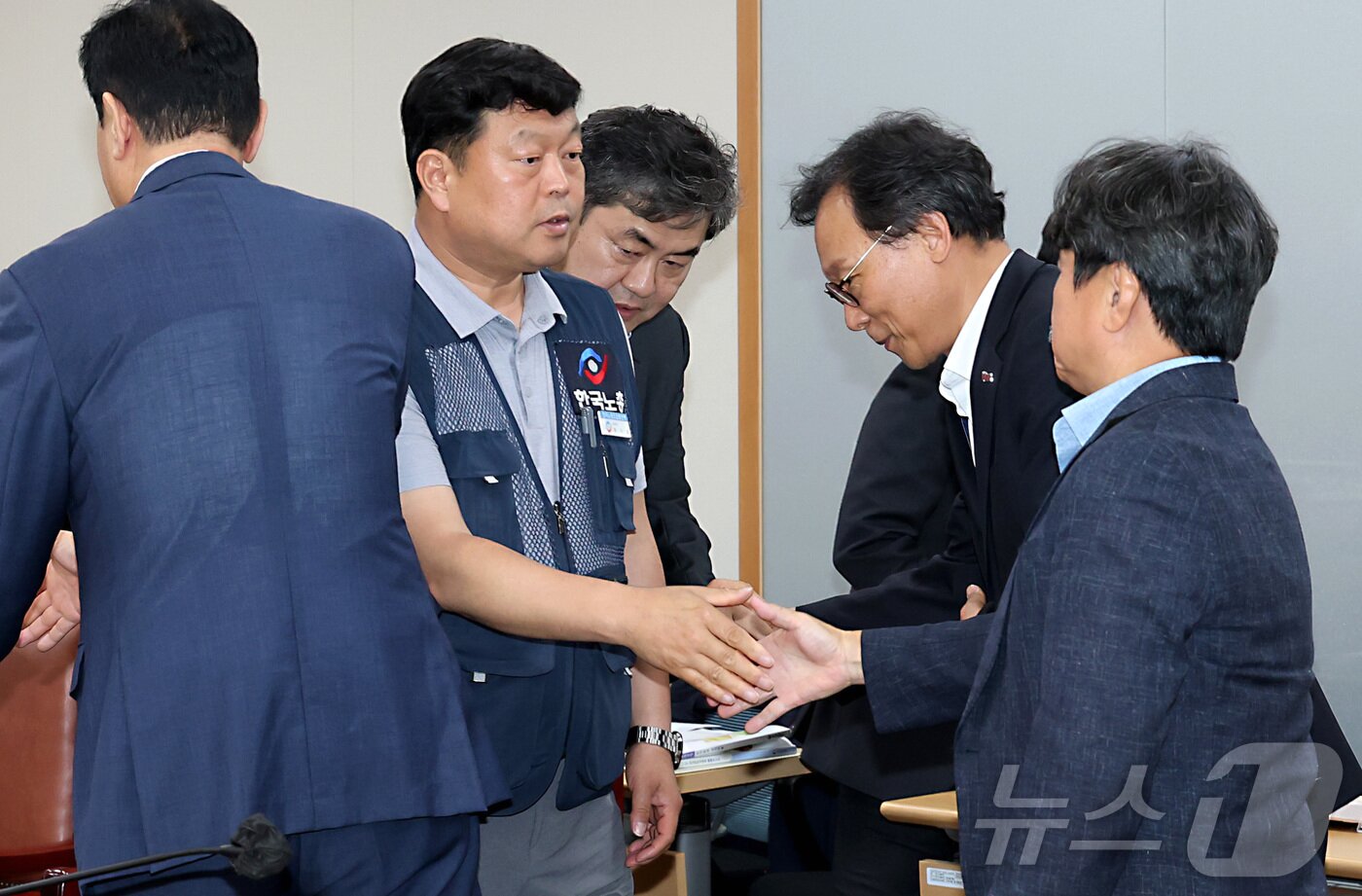 본문 이미지 - 지난 10일 저녁 세종시 정부세종청사 고용노동부에서 열린 최저임금위원회 제12차 전원회의에서 사용자위원과 한국노총 근로자위원들만이 참여하여 2026년 최저임금을 10,320원으로 합의하며 류기섭 근로자위원과 권순원 공익위원이 악수를 나누고 있다. 2025.7.11/뉴스1 ⓒ News1 김기남 기자