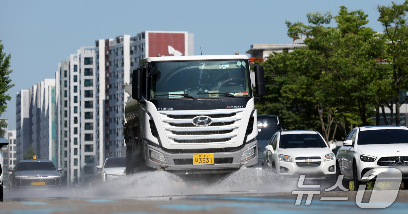 (수원=뉴스1) 김영운 기자 = 연일 폭염이 이어지고 있는 11일 경기 수원시 팔달구 수원시청 인근에서 구청 관계자가 살수차를 이용해 물을 뿌리고 있다. 2025.7.11/뉴스1