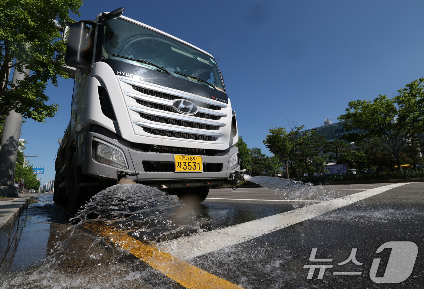 (수원=뉴스1) 김영운 기자 = 연일 폭염이 이어지고 있는 11일 경기 수원시 팔달구 수원시청 인근에서 구청 관계자가 살수차를 이용해 물을 뿌리고 있다. 2025.7.11/뉴스1