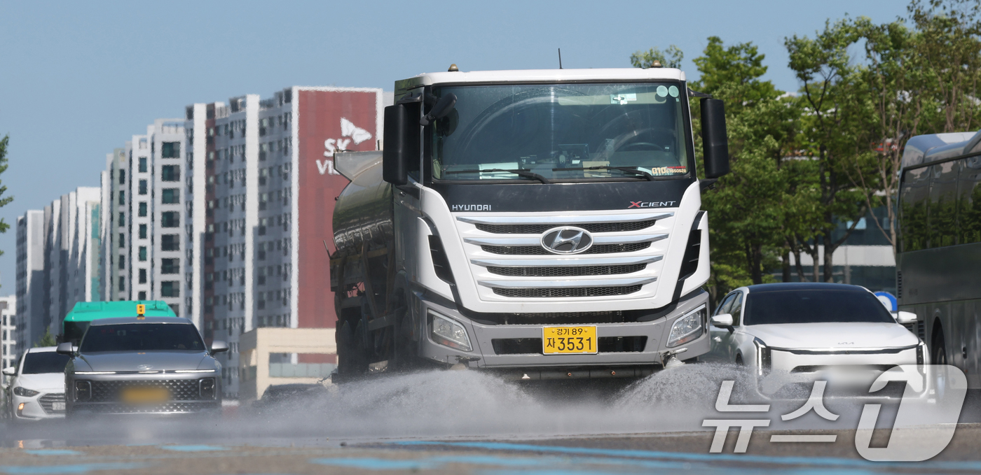 (수원=뉴스1) 김영운 기자 = 연일 폭염이 이어지고 있는 11일 경기 수원시 팔달구 수원시청 인근에서 구청 관계자가 살수차를 이용해 물을 뿌리고 있다. 2025.7.11/뉴스1