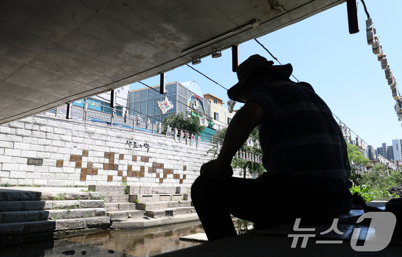 (수원=뉴스1) 김영운 기자 = 연일 폭염이 이어지고 있는 11일 경기 수원시 팔달구 지동교 인근 다리 그늘에서 한 어르신이 더위를 피해 휴식을 취하고 있다. 2025.7.11/뉴 …