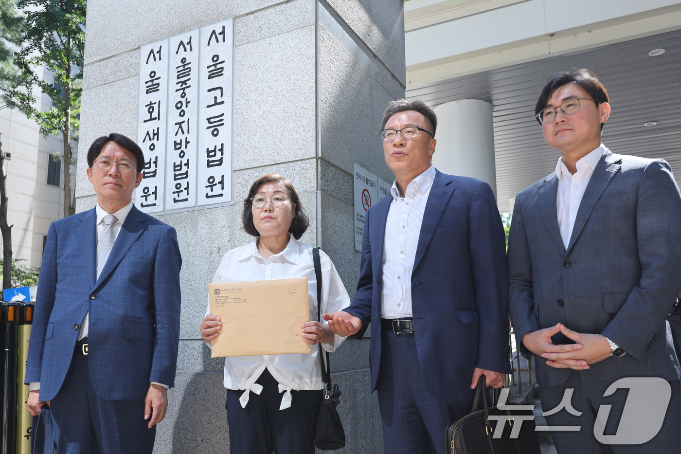 (서울=뉴스1) 신웅수 기자 = 최민경 북한감금피해자가족회 대표(왼쪽 두 번째)와 북한인권정보센터 인권침해지원센터 회원들이 11일 오후 서울 서초구 서울중앙지방법원 앞에서 김정은 …