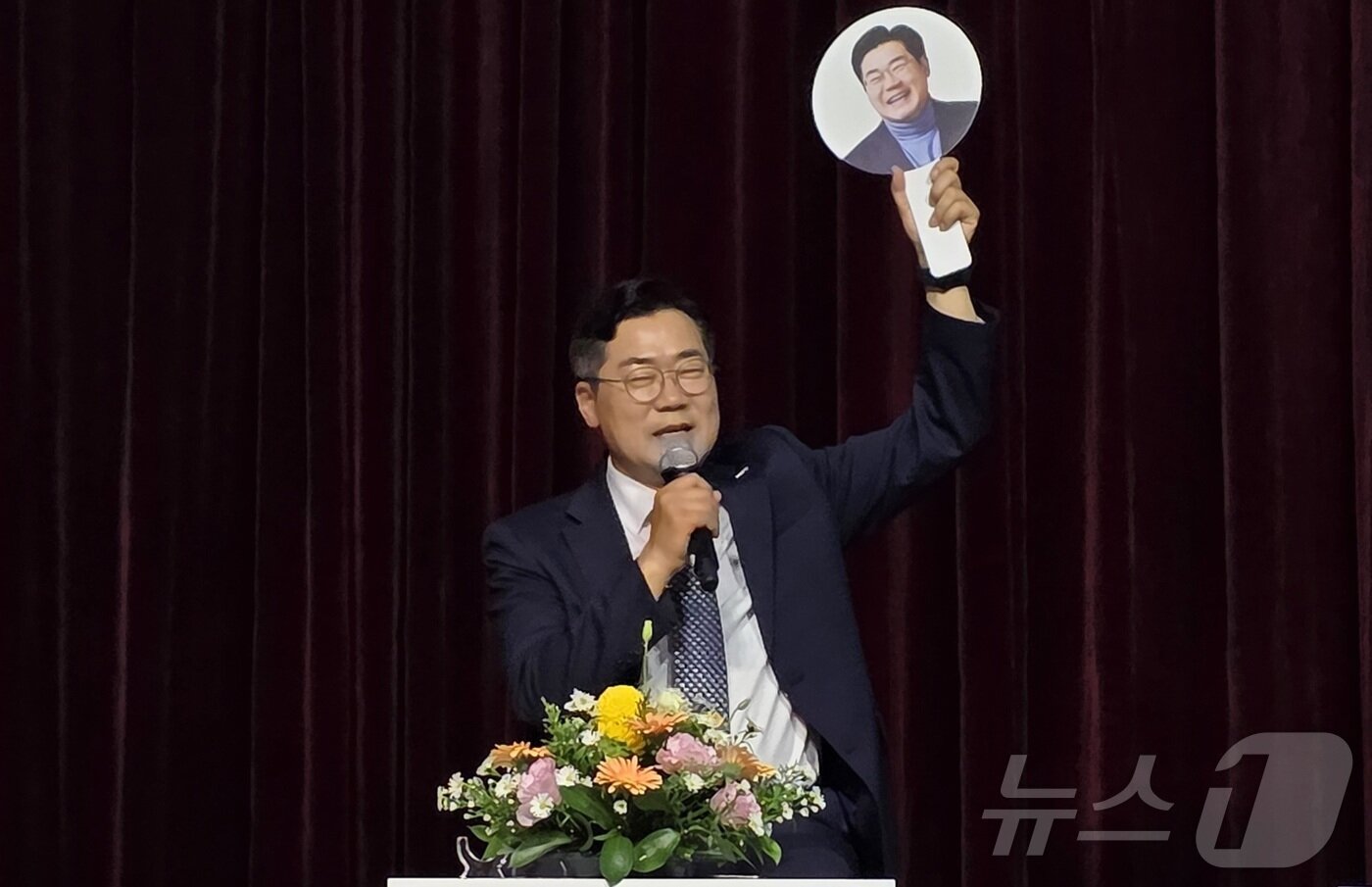 본문 이미지 - 박찬대 더불어민주당 당대표 후보가 12일 충남 천안시 서북구 나사렛대학교 패치홀에서 열린 &#39;더불어민주당 당대표 후보 게릴라 토크콘서트&#39;에서 자신의 얼굴이 그려진 손팻말을 들고 발언 기회를 요구하고 있다. 2025.7.12/뉴스1 ⓒ News1 이시우 기자