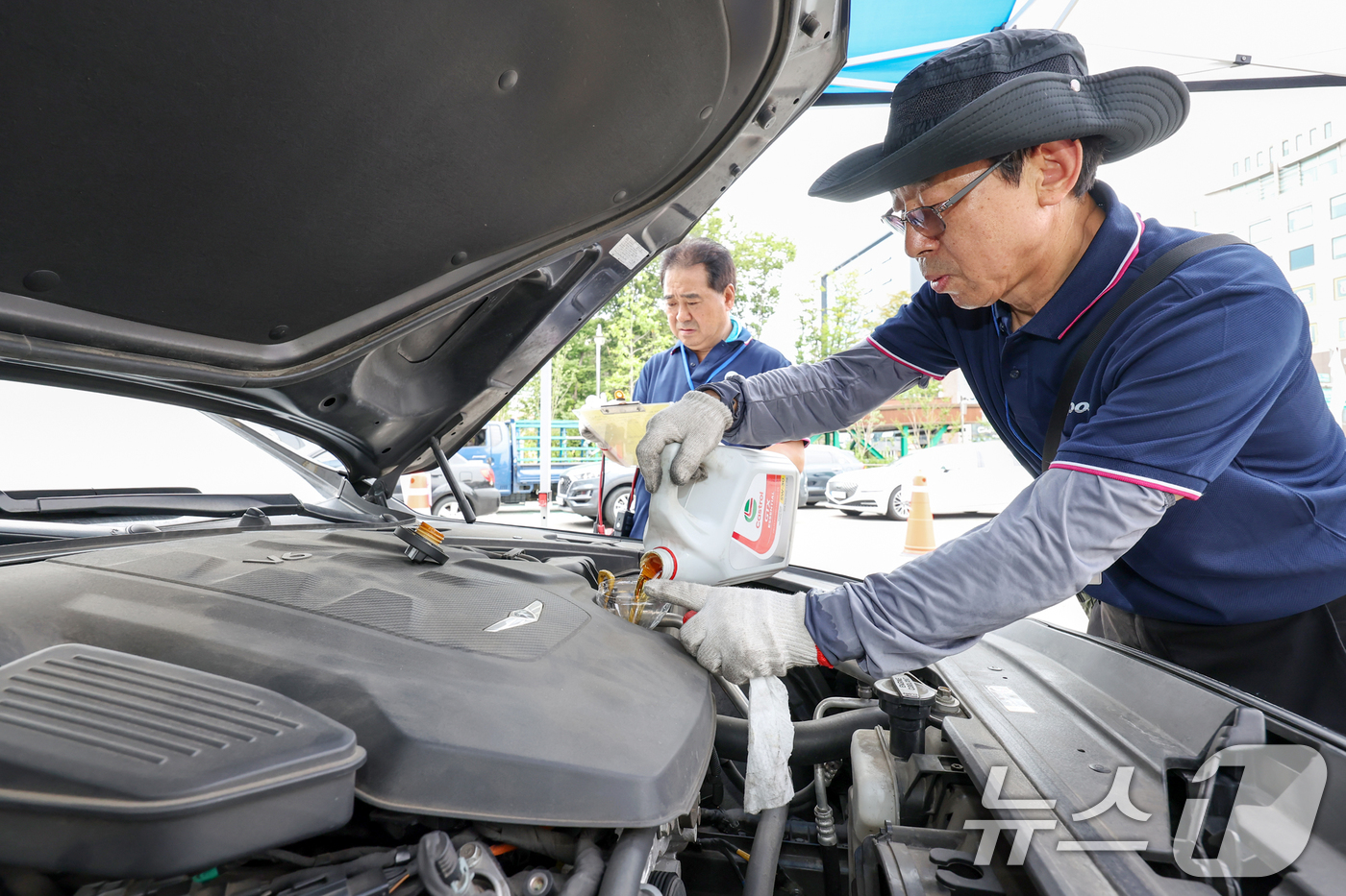 (서울=뉴스1) 민경석 기자 = 서울시 자동차전문정비사업조합(카포스) 송파구지회 정비사들이 13일 서울 송파구민회관 주차장에서 여름 휴가철을 맞아 차량 무상점검을 실시하고 있다. …