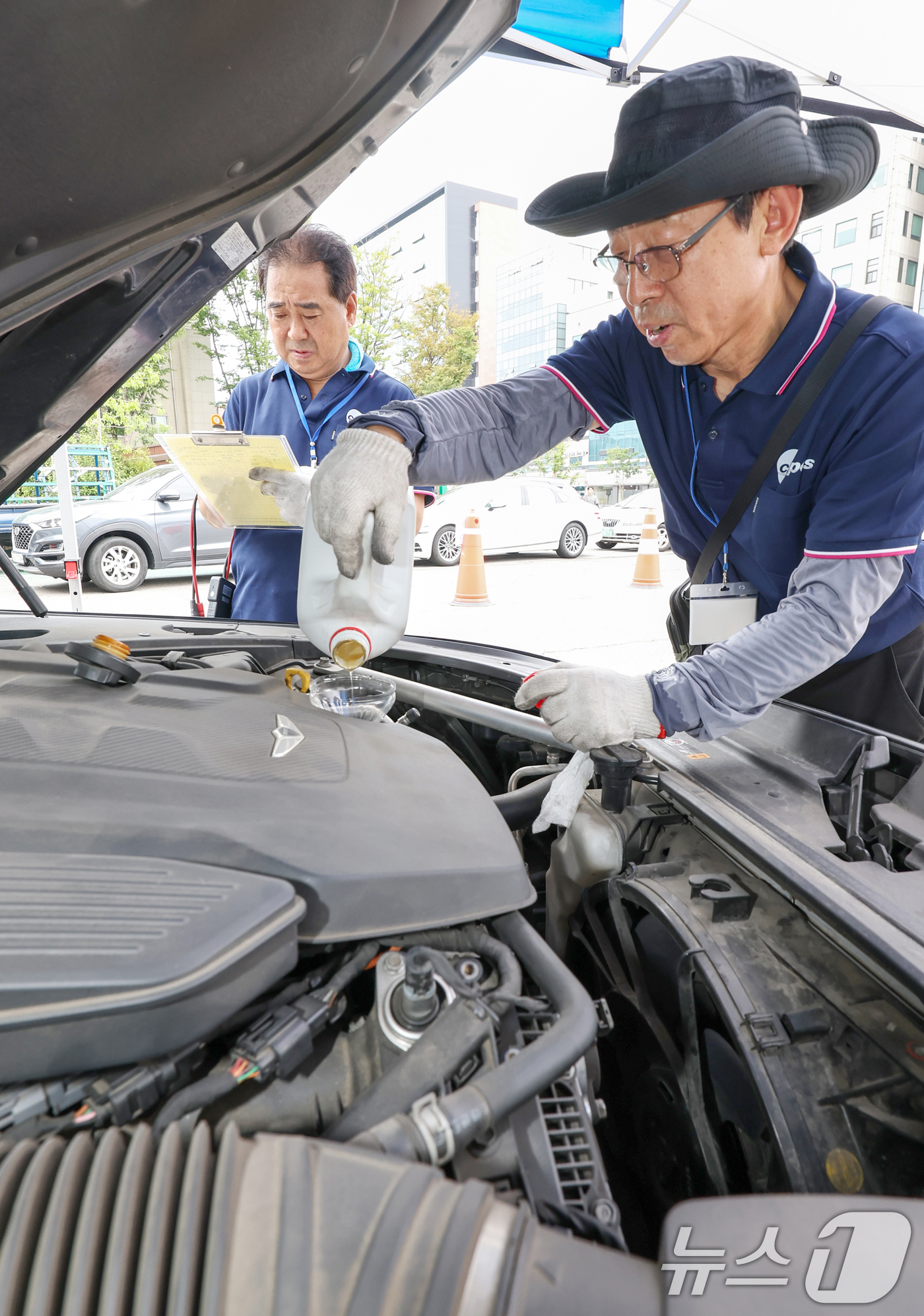 (서울=뉴스1) 민경석 기자 = 서울시 자동차전문정비사업조합(카포스) 송파구지회 정비사들이 13일 서울 송파구민회관 주차장에서 여름 휴가철을 맞아 차량 무상점검을 실시하고 있다. …
