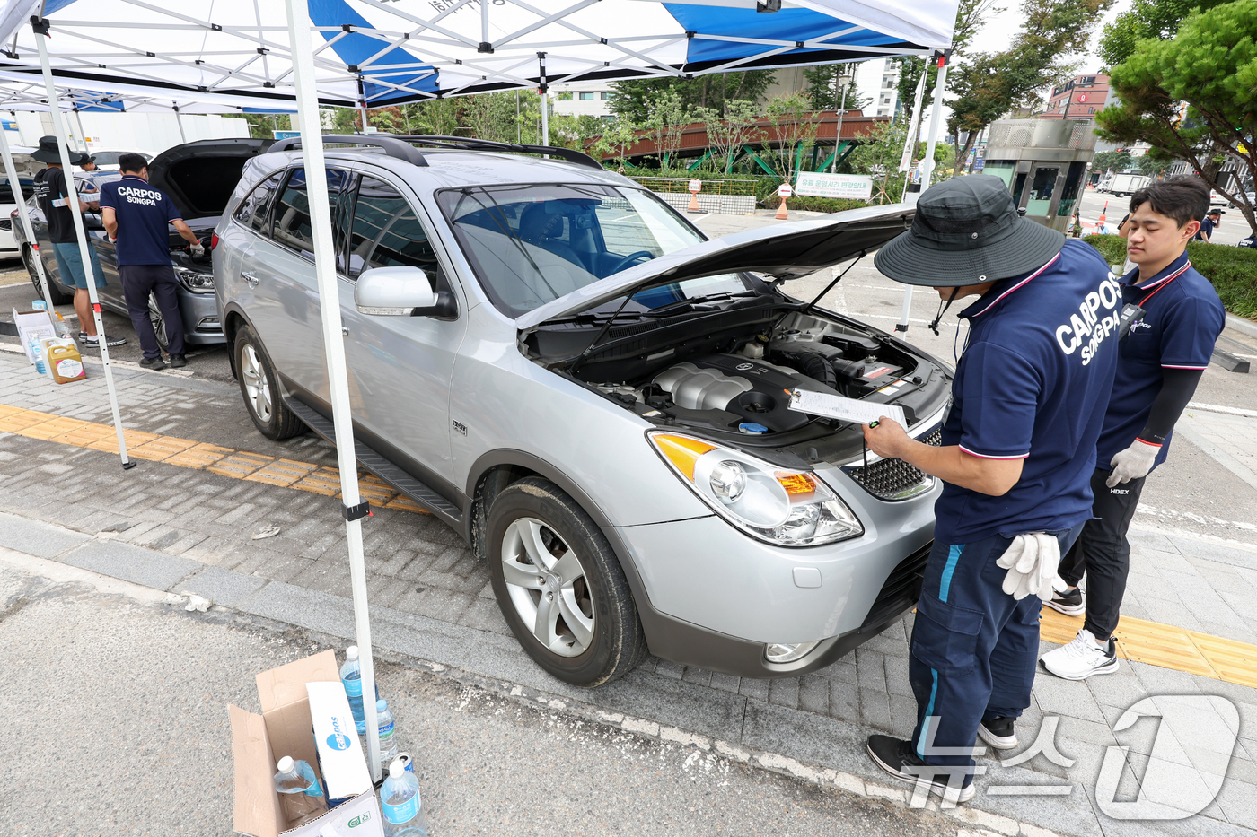(서울=뉴스1) 민경석 기자 = 서울시 자동차전문정비사업조합(카포스) 송파구지회 정비사들이 13일 서울 송파구민회관 주차장에서 여름 휴가철을 맞아 차량 무상점검을 실시하고 있다. …
