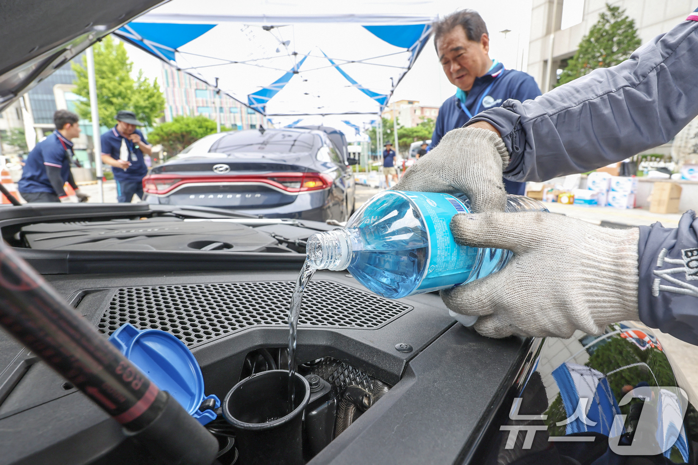 (서울=뉴스1) 민경석 기자 = 서울시 자동차전문정비사업조합(카포스) 송파구지회 정비사들이 13일 서울 송파구민회관 주차장에서 여름 휴가철을 맞아 차량 무상점검을 실시하고 있다. …