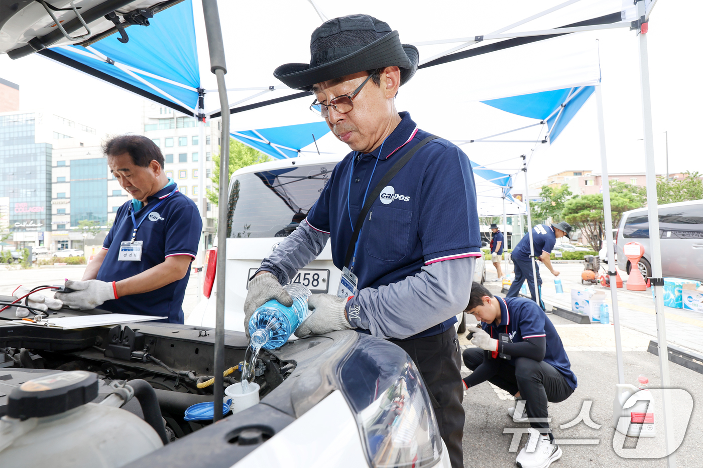(서울=뉴스1) 민경석 기자 = 서울시 자동차전문정비사업조합(카포스) 송파구지회 정비사들이 13일 서울 송파구민회관 주차장에서 여름 휴가철을 맞아 차량 무상점검을 실시하고 있다. …