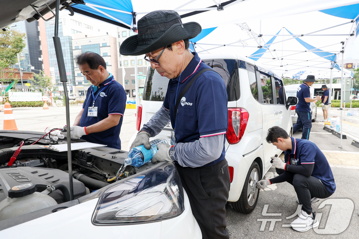 (서울=뉴스1) 민경석 기자 = 서울시 자동차전문정비사업조합(카포스) 송파구지회 정비사들이 13일 서울 송파구민회관 주차장에서 여름 휴가철을 맞아 차량 무상점검을 실시하고 있다. …