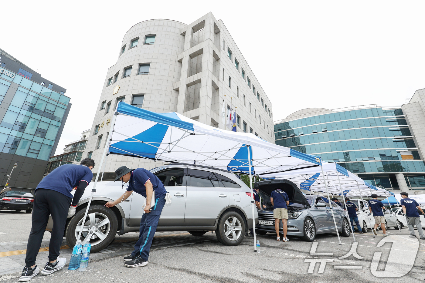 (서울=뉴스1) 민경석 기자 = 서울시 자동차전문정비사업조합(카포스) 송파구지회 정비사들이 13일 서울 송파구민회관 주차장에서 여름 휴가철을 맞아 차량 무상점검을 실시하고 있다. …