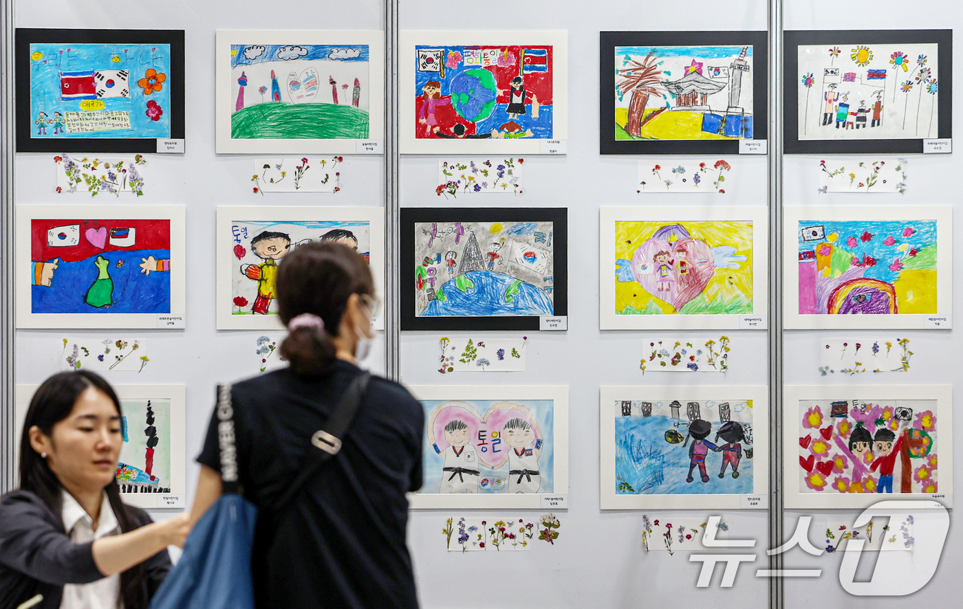 (서울=뉴스1) 민경석 기자 = 13일 서울 강남구 코엑스에서 열린 '제2회 북한이탈주민의날 문화행사'에 마련된 민주평화통일자문회의 서울중구협의회 부스에 어린이들이 통일을 희망하며 …